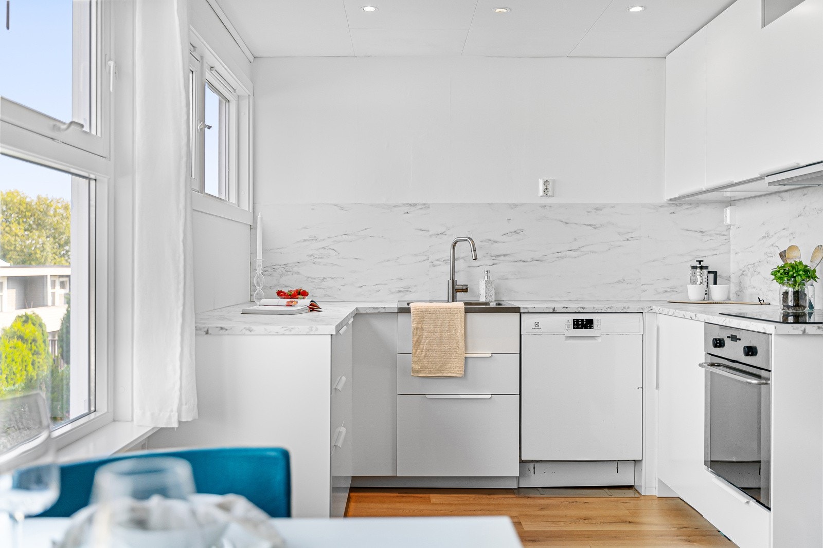 Moderne løsninger på kjøkkenet gir et stilrent uttrykk, med hvite overflater og praktiske detaljer. Galleribilde