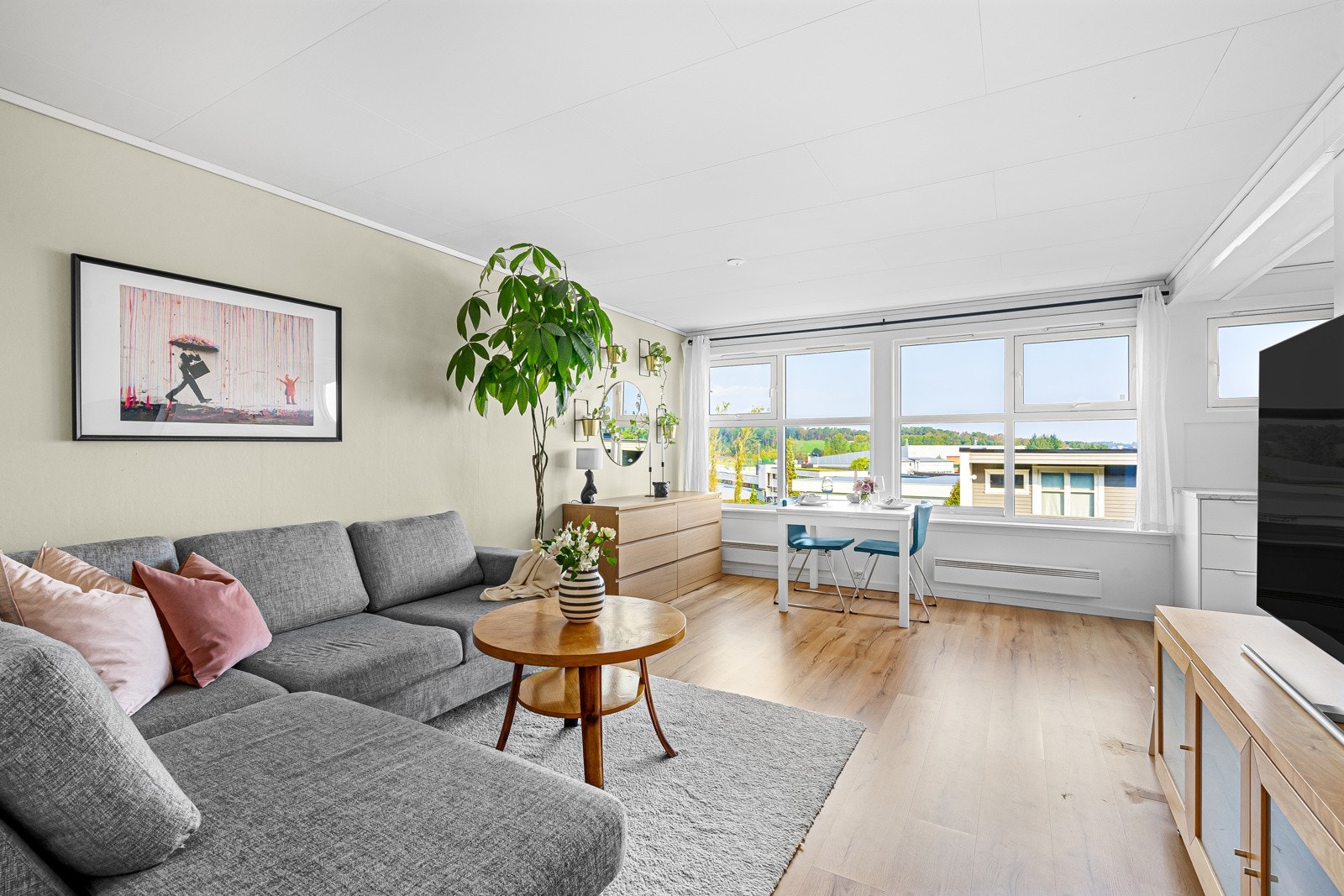 Store vinduer gir rikelig med lys, noe som skaper en lys og romslig atmosfære i oppholdsrommet. Galleribilde