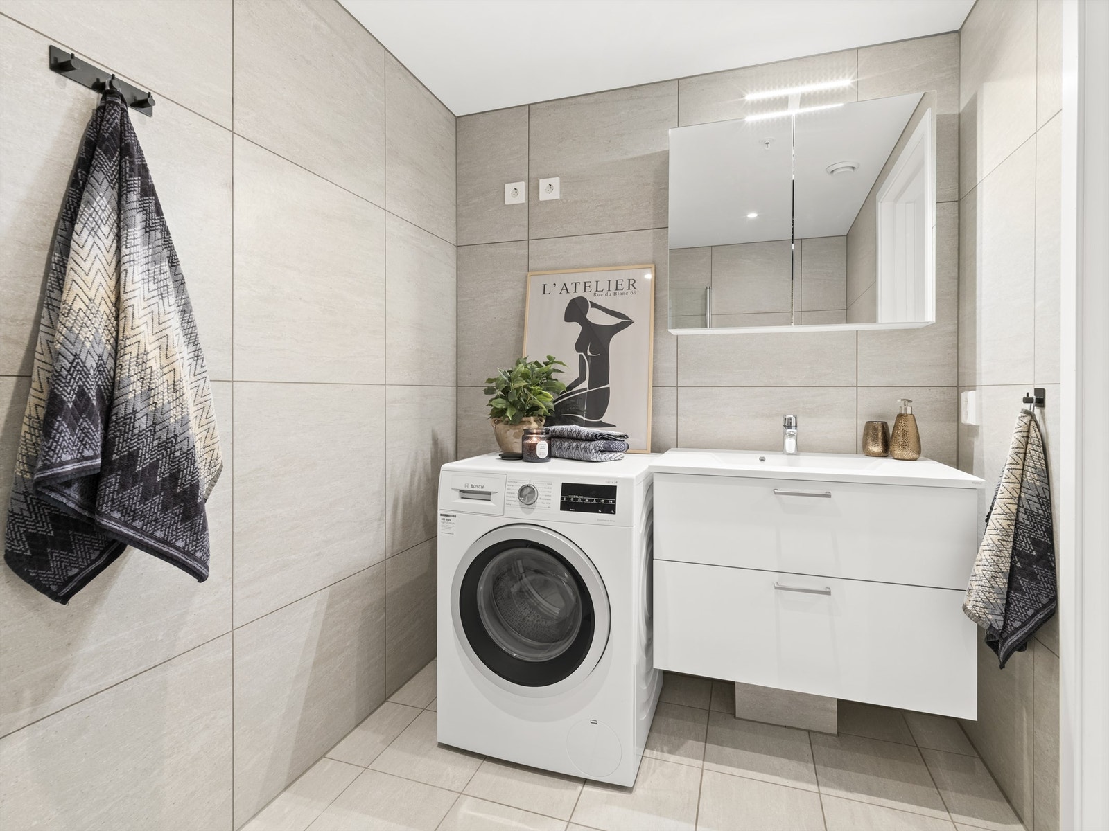 Fliser i grå nyanser på både gulv og vegger fremmer helhet på badet. Galleribilde