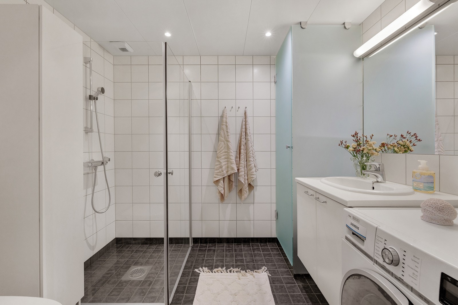Lyst, delikat bad med elektriske varmekabler i gulv og downlights i tak Galleribilde
