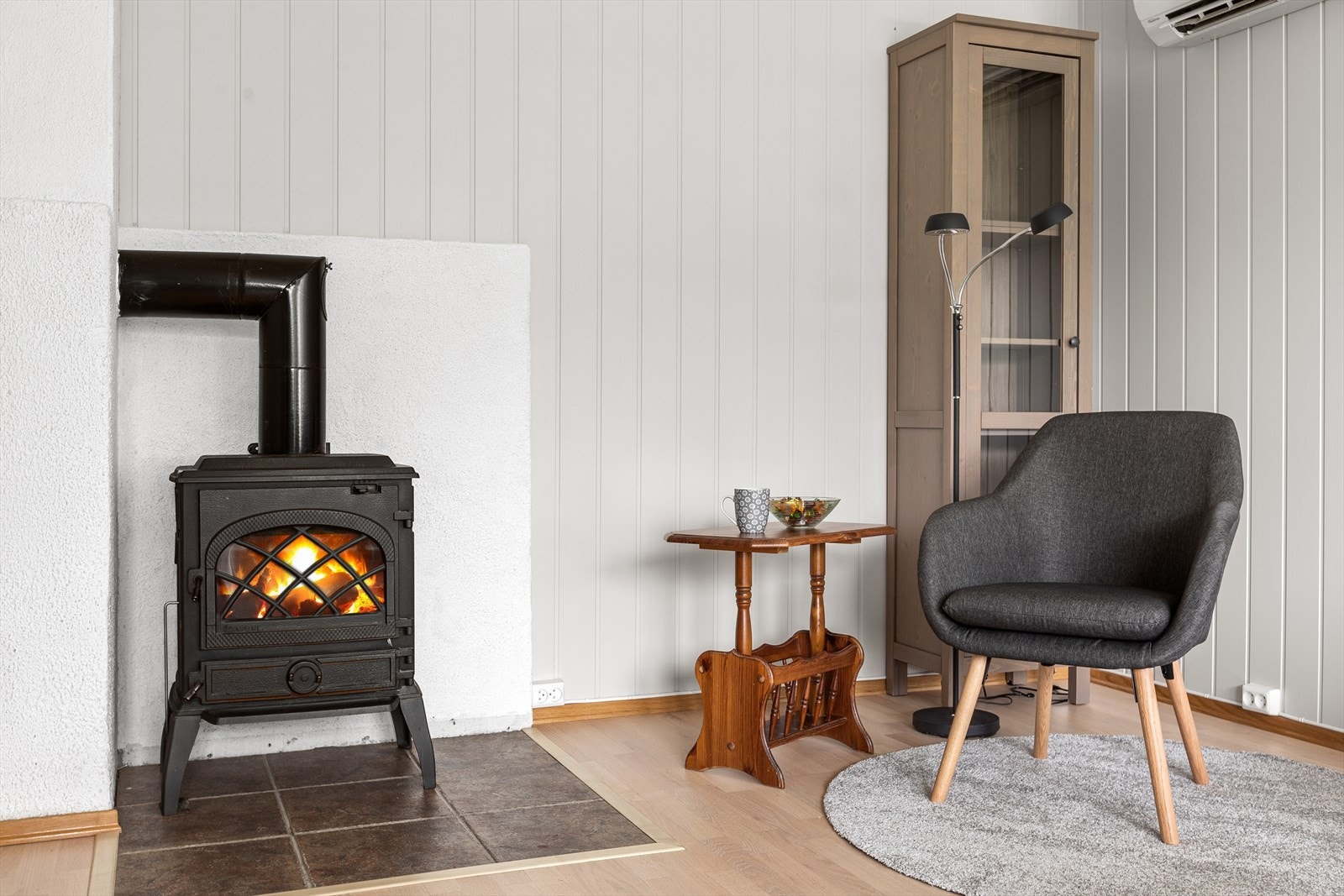 Stuen har både peisovn og varmepumpe, og oppleves som lun og koselig Galleribilde