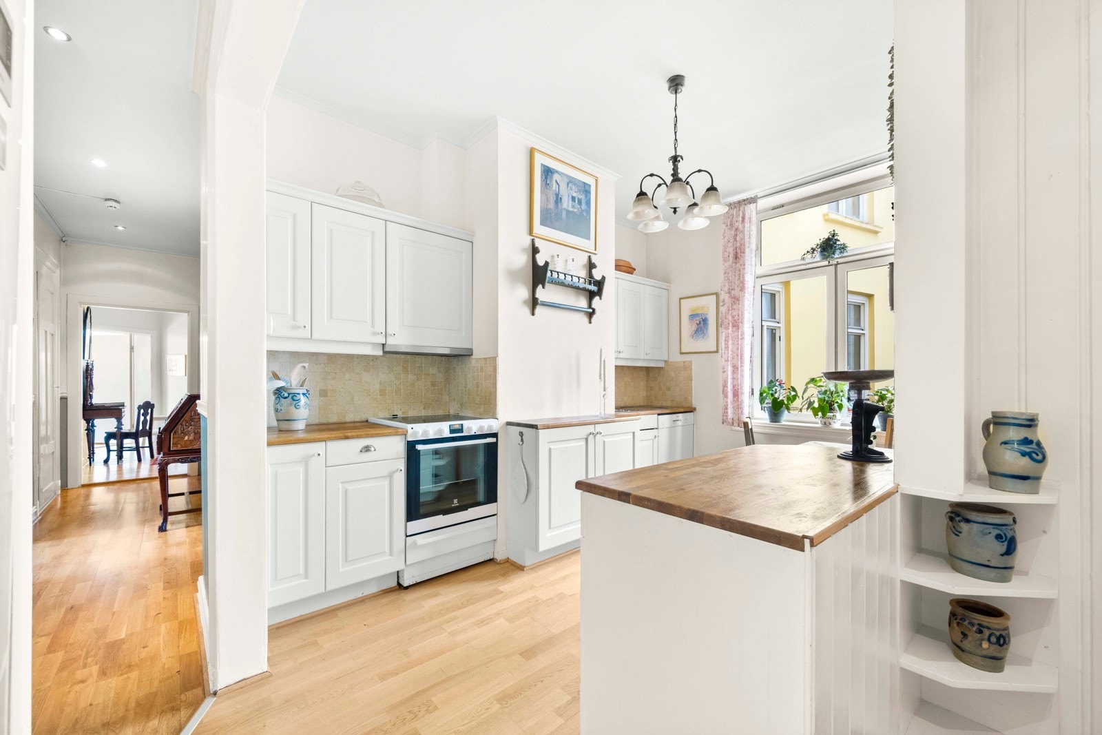 Her er det godt med både skap- og benkeplass. På veggen over kjøkkenbenken er det dekorative fliser og det er belysning og stikkontakt under overskapene Galleribilde