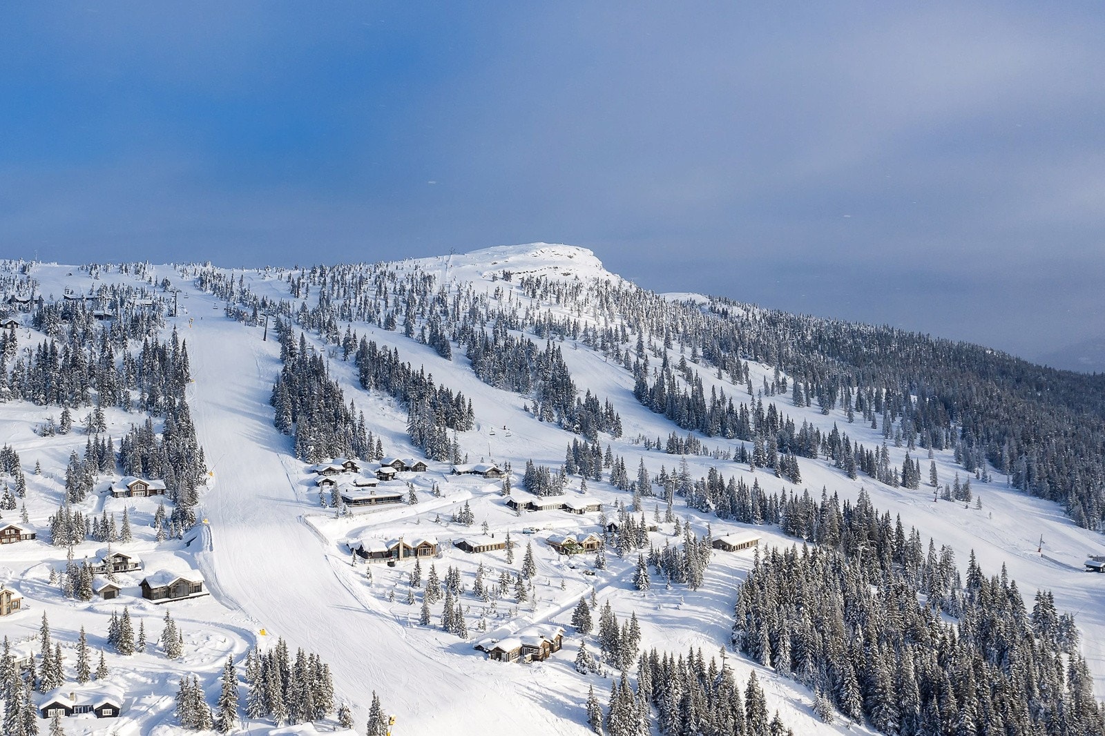 Illustrasjon av hytta i vinterdrakt som viser en flott beliggenhet inntil bakken Galleribilde