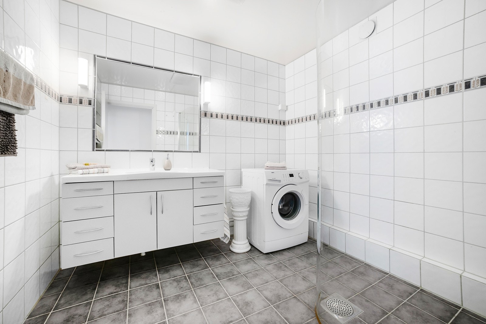 Badet er pusset opp med fliser på gulv innredning med mye skapplass Galleribilde
