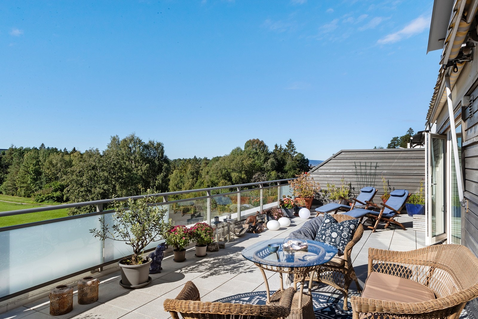 Nylig oppusset terrasse med glassrekkverk og markise Galleribilde
