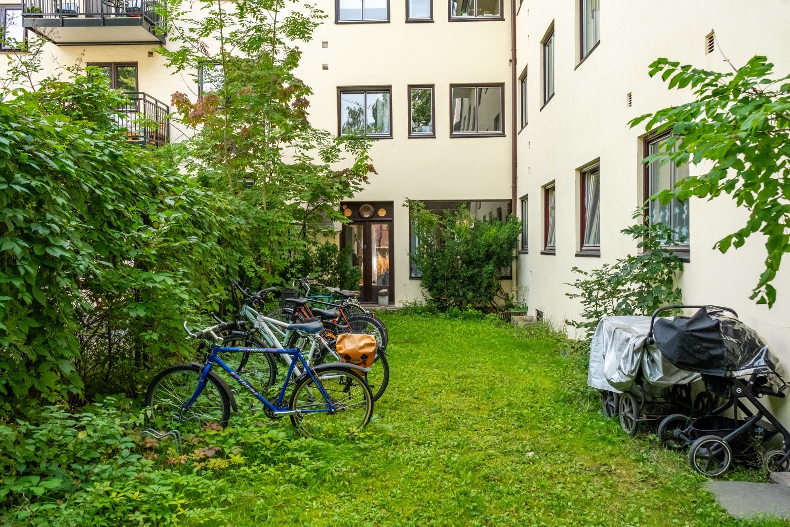 Nå er vi i bakgården rett utenfor leiligheten. Fasaden mot bakhagen ble pusset opp i 2023. Galleribilde