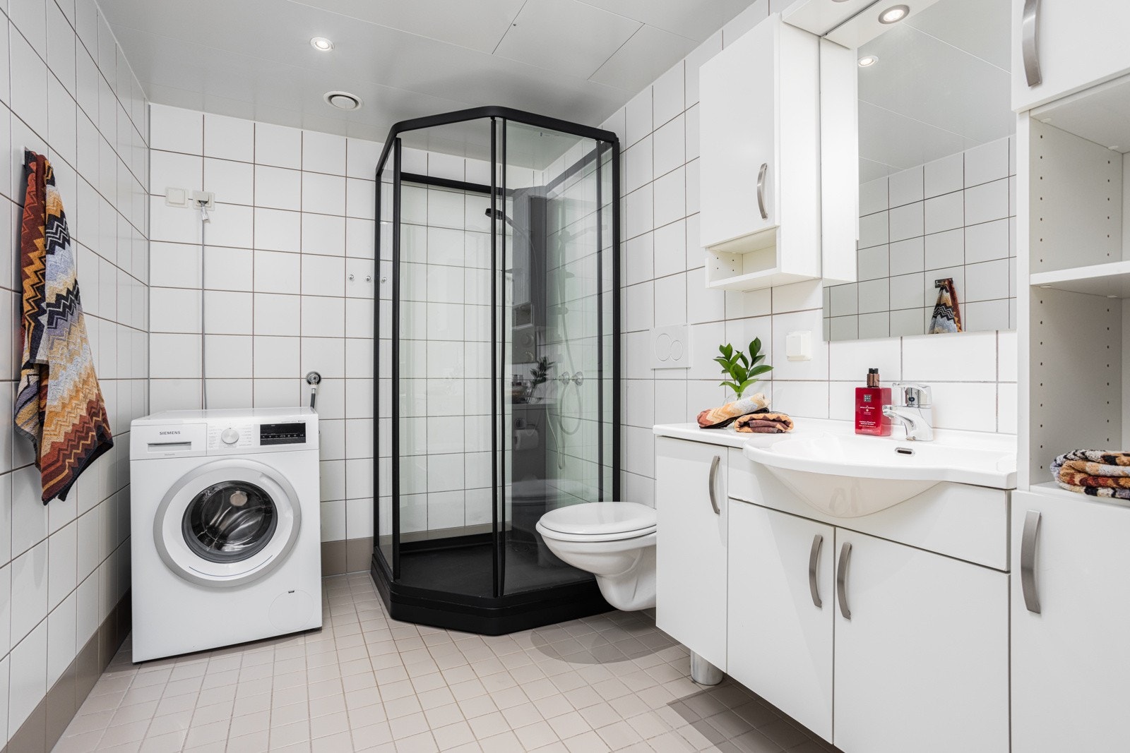 Det flislagte badet følger opp med samme stilrene preg som kjøkkenet. Galleribilde