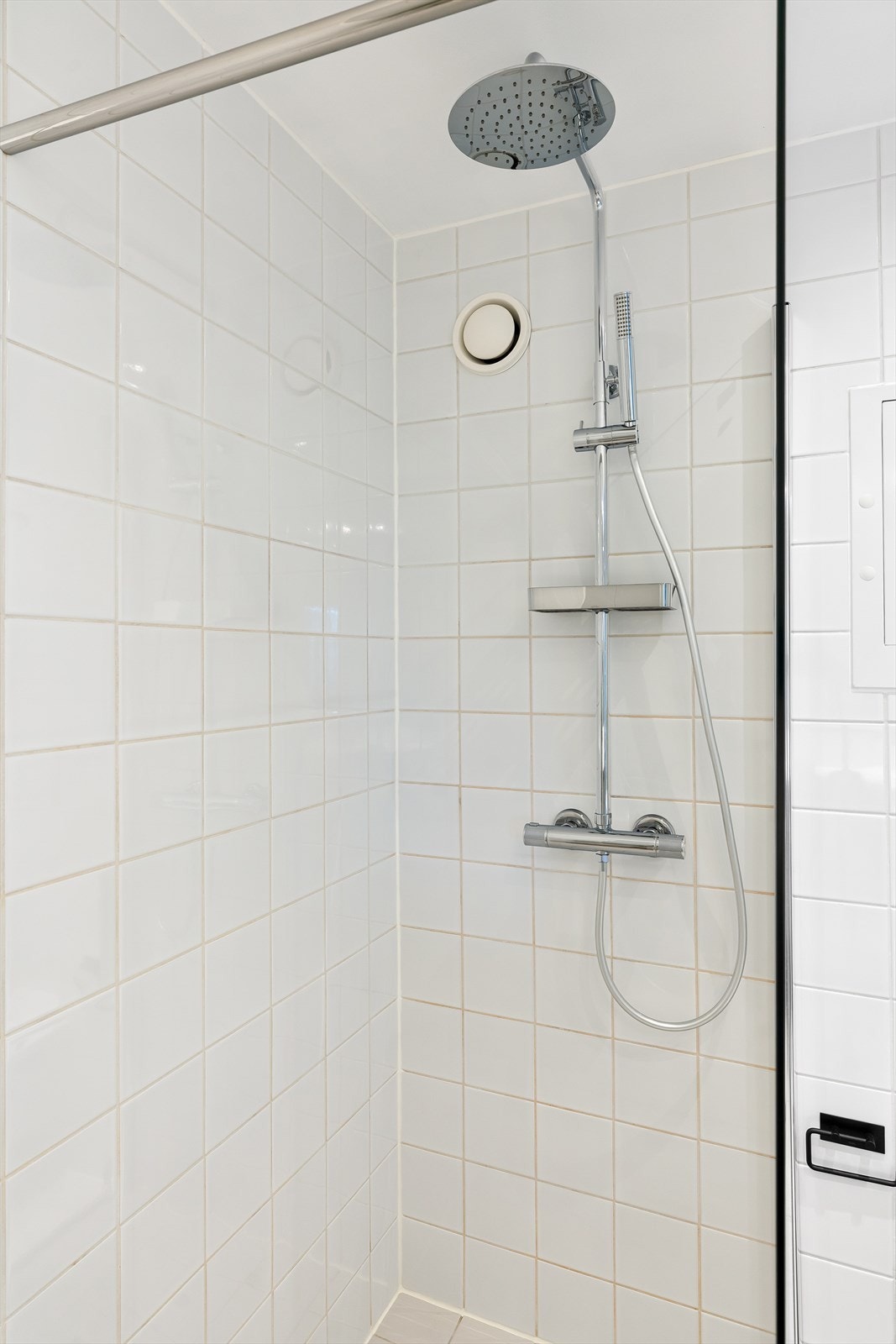 Badet er utstyrt med servant på benkeskap med speil, vegghengt toalett og dusjhjørne med herdet glass. Det er opplegg for vaskemaskin. Galleribilde