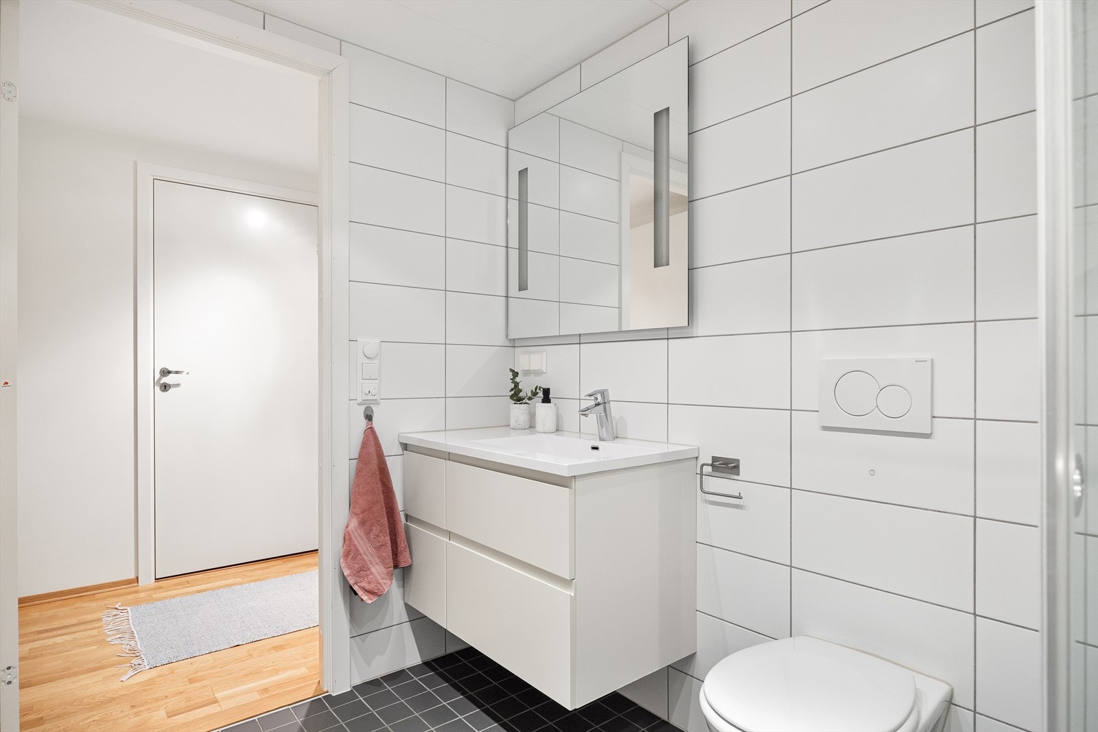 Badet består av servantskap, speil med lys i ramme og opplegg for vaskemaskin. Galleribilde