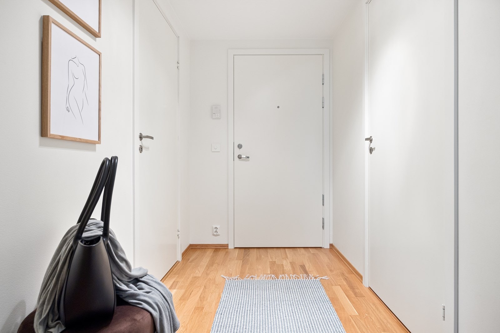 Leiligheten har en innbydende entré som skaper et umiddelbart godt førsteinntrykk. Her kan du enkelt henge i fra deg yttertøy og sette i fra deg sko. Galleribilde