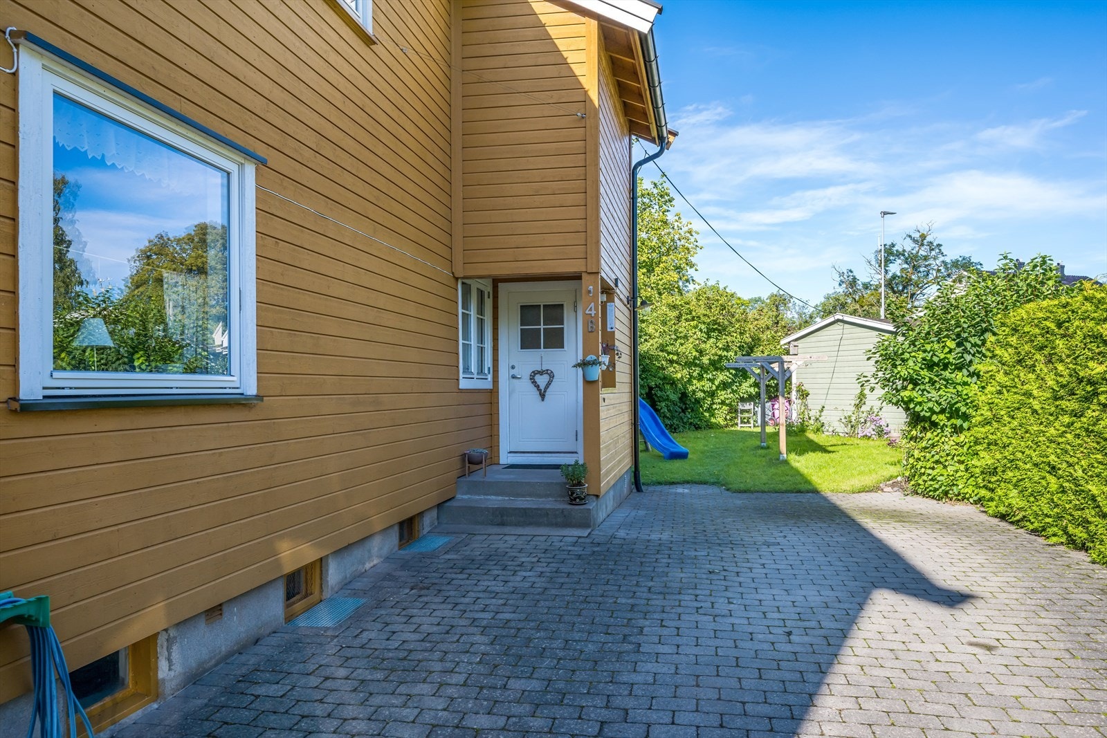 Fasade med inngangsparti. Gårdsplass med belegningsstein. Galleribilde