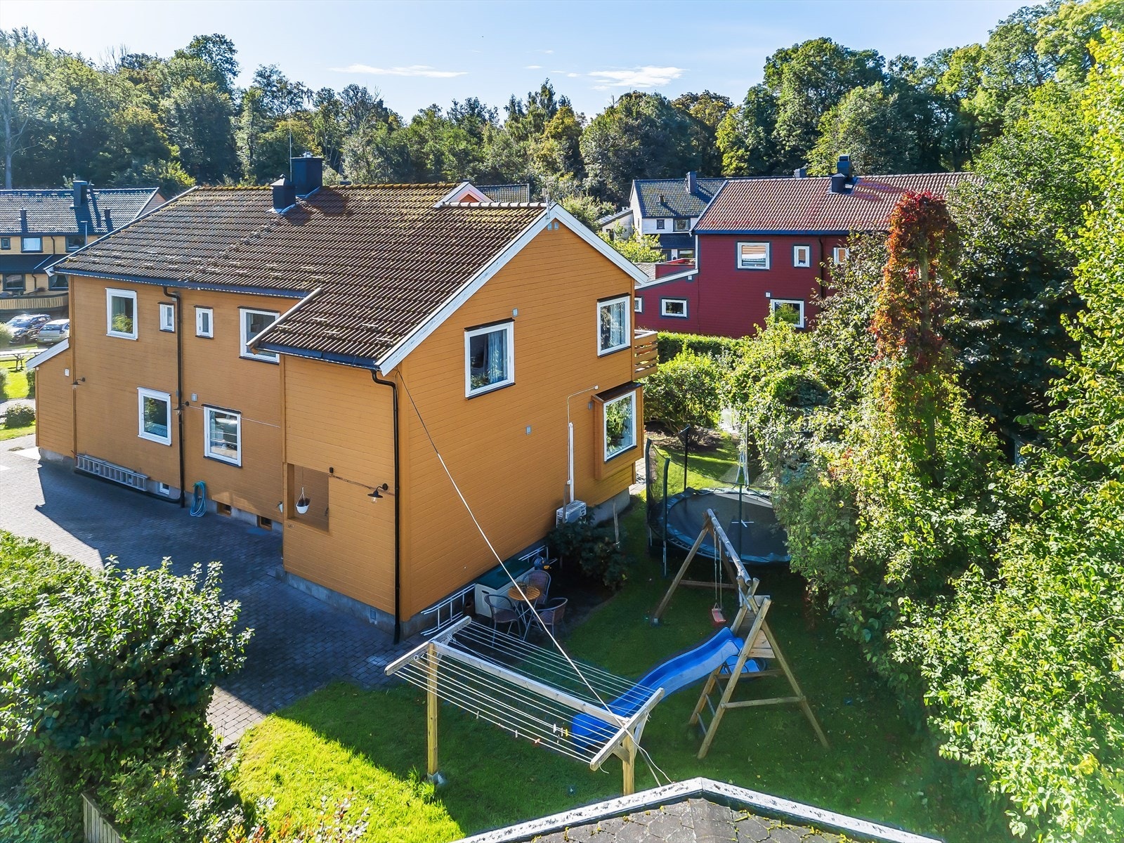 Koselig hage mot nord og vest med gressplen, prydbusker og tørkestativ. Galleribilde