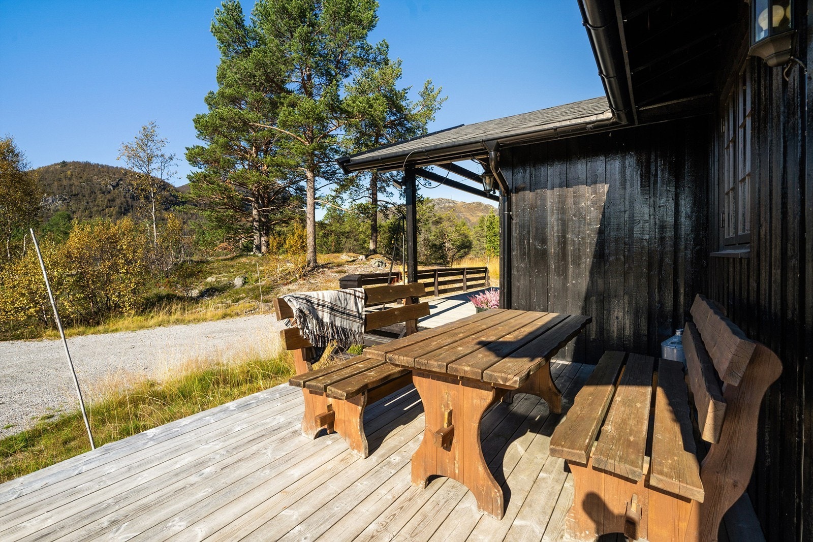 Solrik terrasse utenfor inngangspartiet. Utsikt mot Plassenuten. Skisenteret midt i bildet. Galleribilde