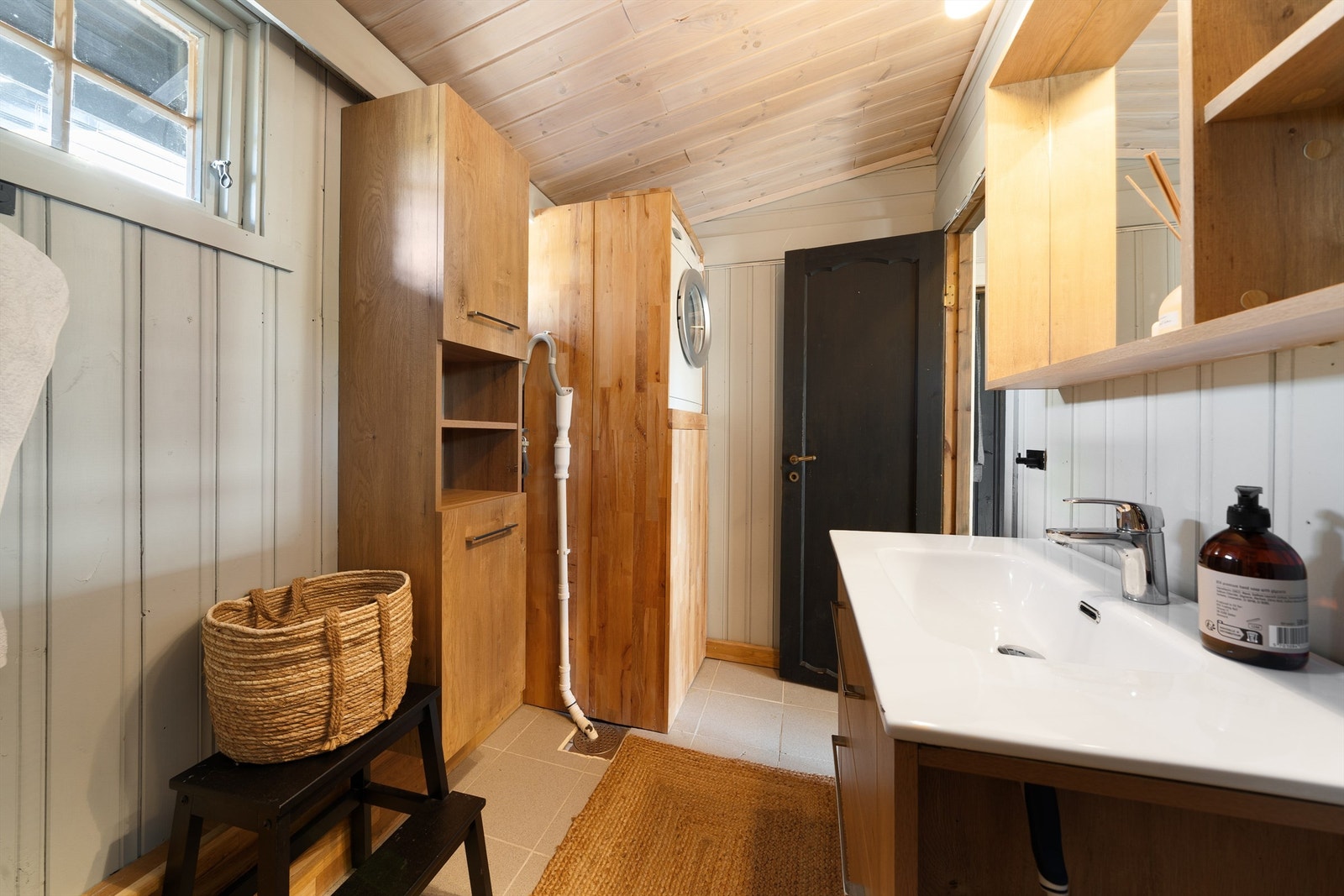 Badet med dusjkabinett, servant med skap, wc og opplegg vaskemaskin. Galleribilde