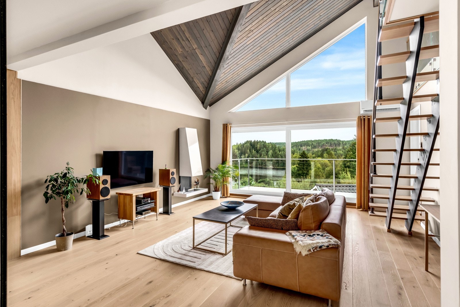 De store vinduene på endeveggen i stuen byr på unik, naturlig lyssetting. Galleribilde