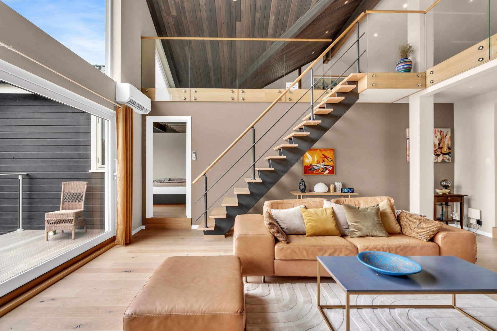 En moderne, stilfull trapp leder fra stuen opp til den luftige hemsen. Galleribilde