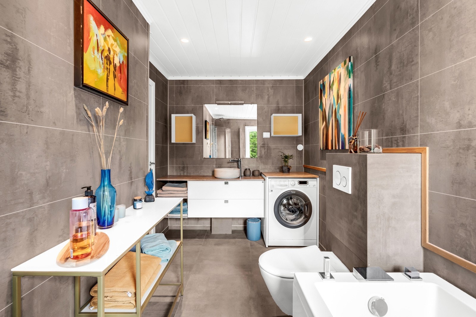 Boligen har et delikat, helfliset bad med elektrisk gulvvarme og opplegg for vaskemaskin. Galleribilde