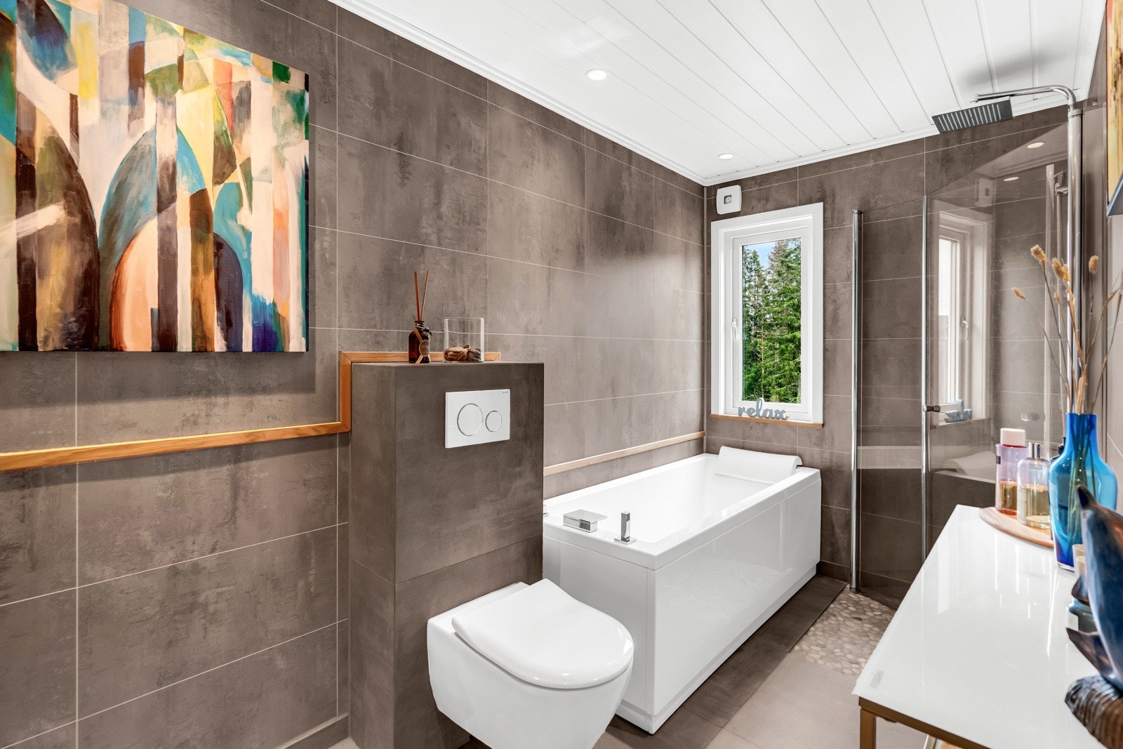 I tillegg til et moderne badekar har badet et dusjhjørne med regnfallsdusj og innfellbare glassdører. Galleribilde