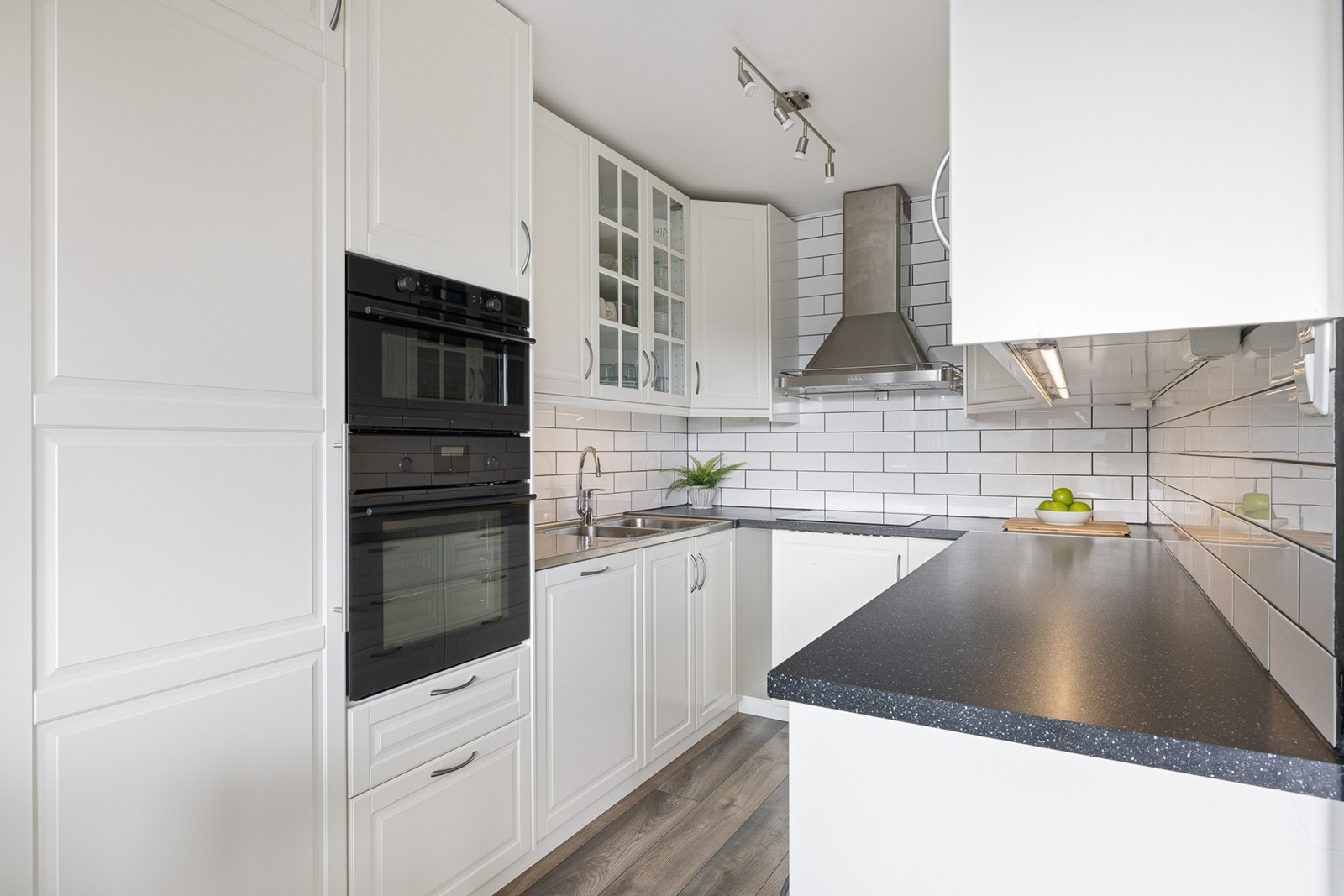 Leiligheten har en moderne hvit kjøkkeninnredning med laminert benkeplate med nedfelt oppvaskkum med 1-greps blandebatteri. Galleribilde