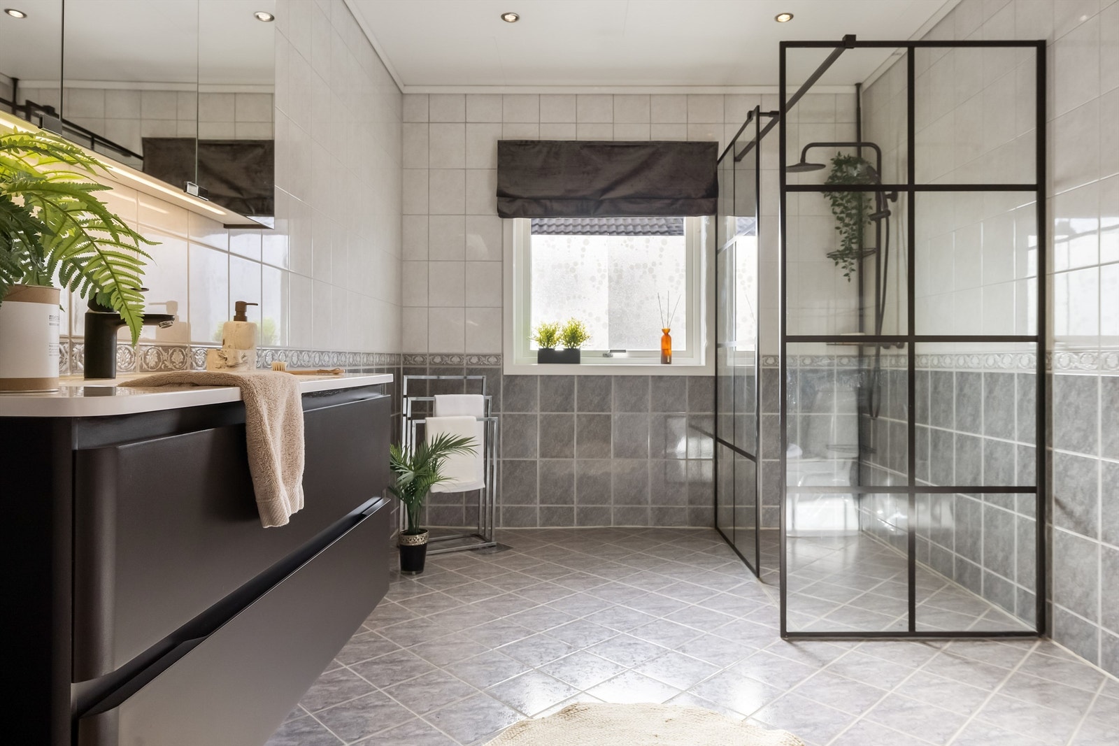 Rommet er romslig og er utstyrt med sorte detaljer som innredning, dusjvegger og dusjarmatur. Galleribilde