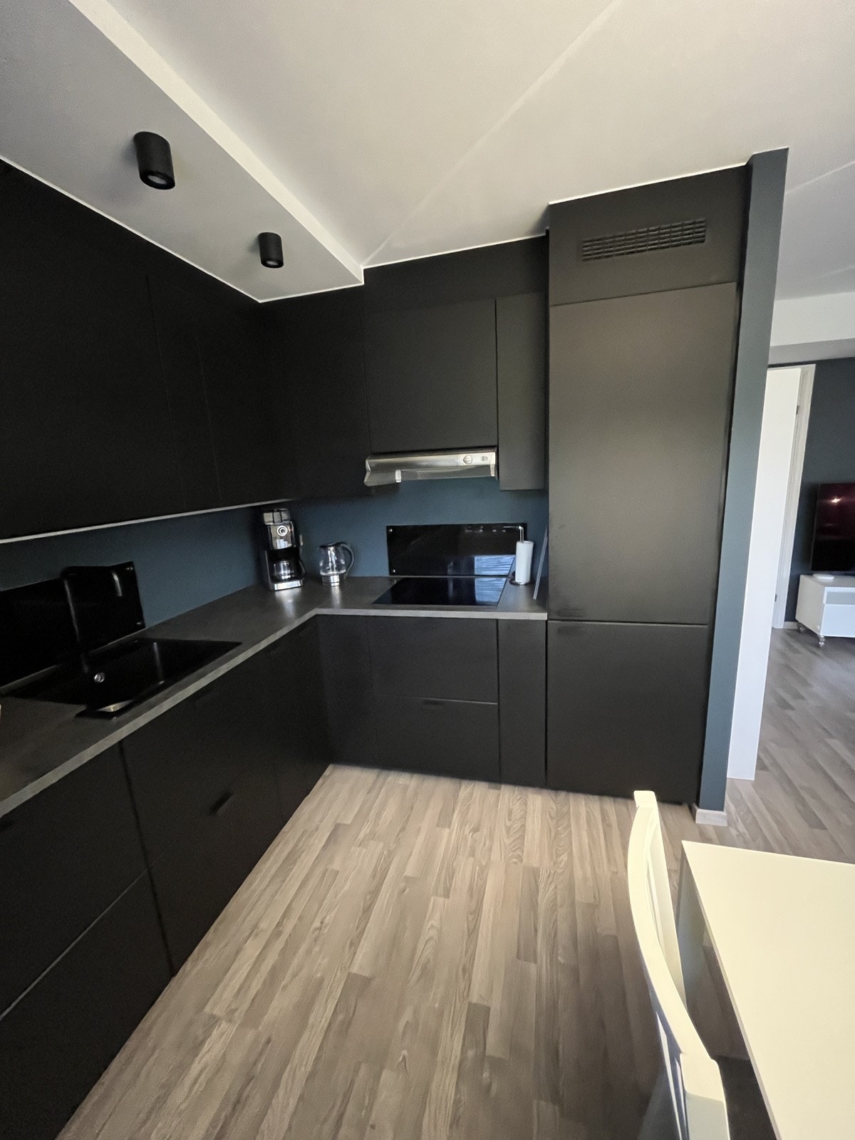 Moderne kjøkken med integrerte hvitevarer og spiseplass. Galleribilde