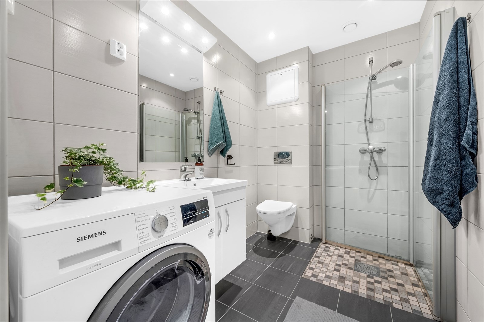 Romslig flislagt bad fra 2011 med opplegg for vaskemaskin Galleribilde