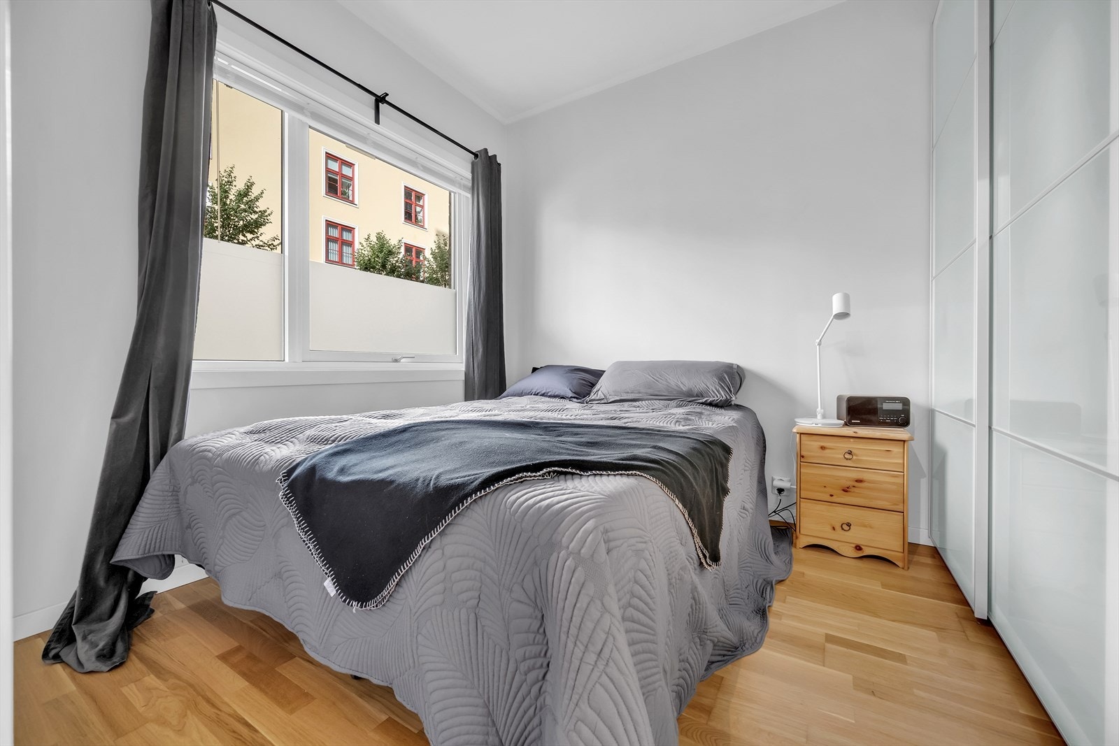 Lunt soverom med god plass til dobbeltseng og tilhørende møblement Galleribilde