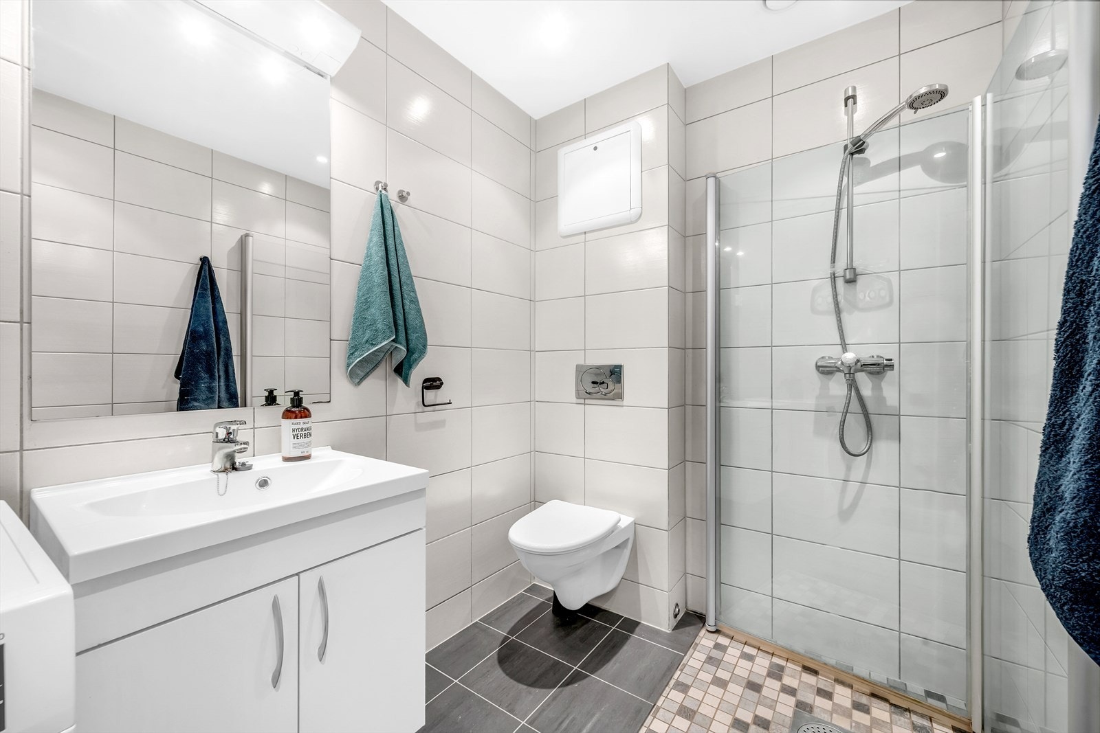 Innredningen består av servantskap med underskap, gulvmontert toalett og dusjhjørne med inn-utadslående dusjvegger Galleribilde