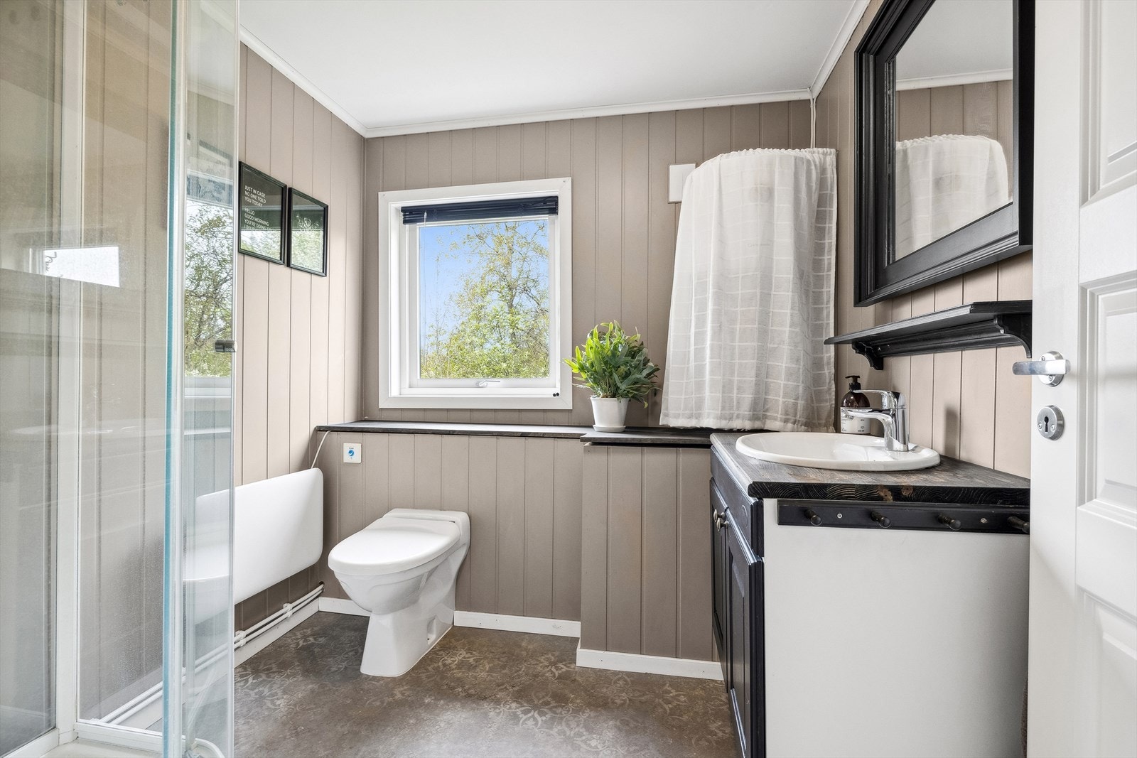 Hytta har et stilig bad, og byr på servant, dusjkabinett og gulv-montert toalett Galleribilde