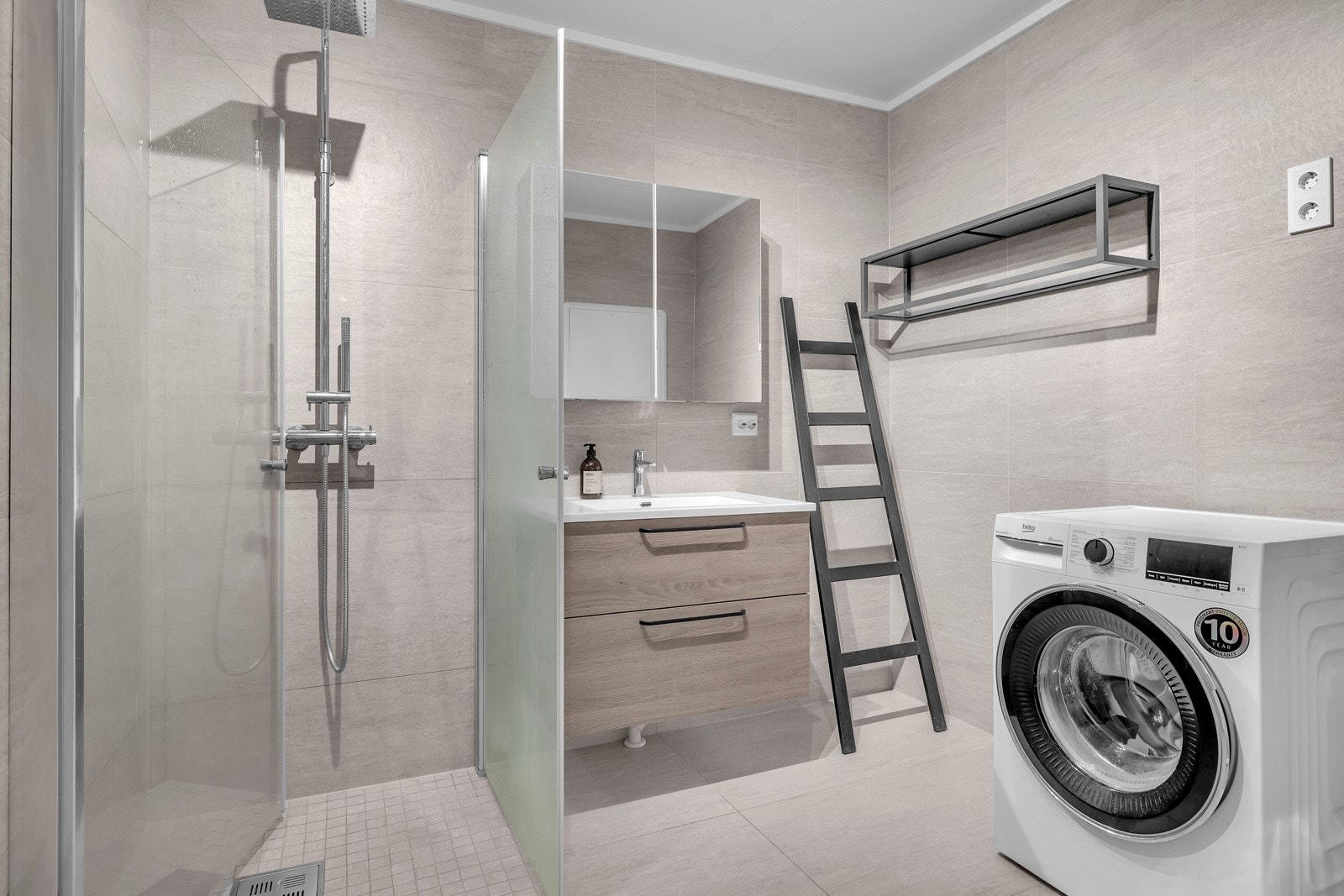 Badet er flislagt på gulv og vegger, er praktisk innredet, har opplegg for vaskemaskin og tørketrommel og er på 6m2 Galleribilde