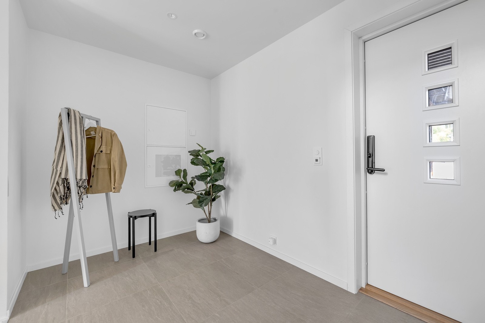 Velkommen inn! Det første som møter deg er dette lyse og fine inngangspartiet på 6.6m2 hvor du finner god plass til både heng og garderobe Galleribilde