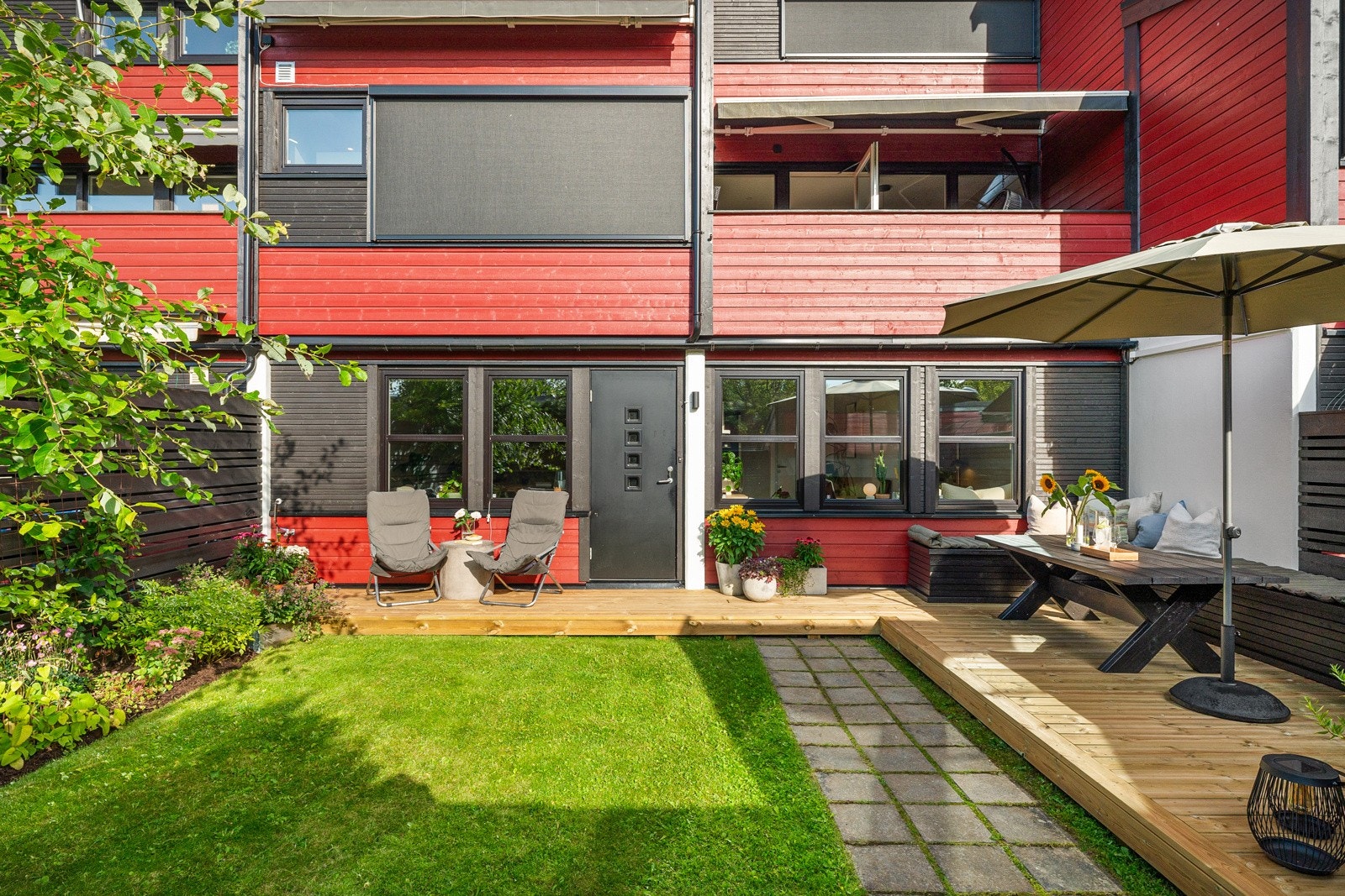 Uteområdet vender mot vest og er opparbeidet med gressplen, terrasse og beplantninger Galleribilde