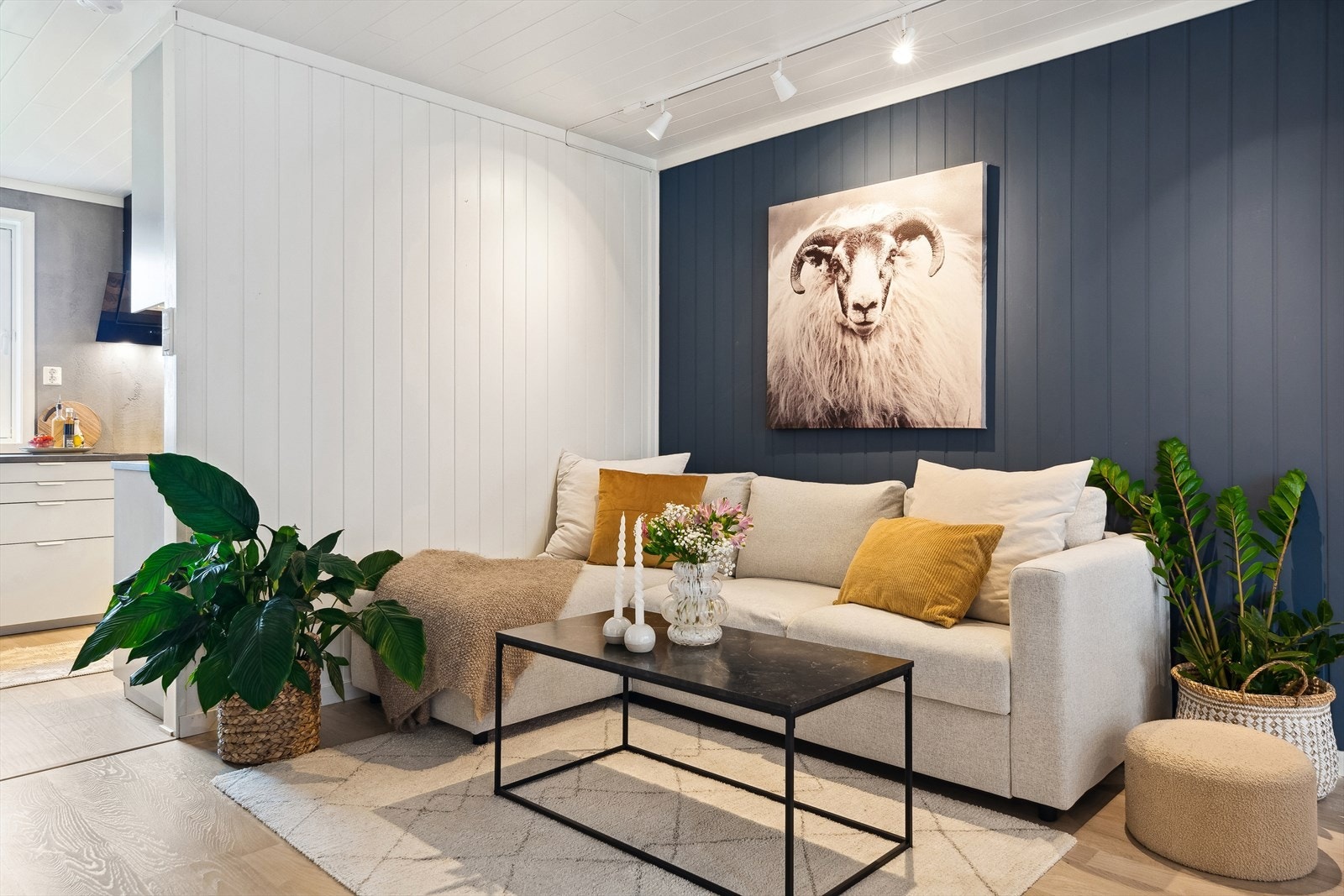 Stuen er et flott rom med en kombinasjon av laminatgulv, hvitmalt veggpanel og stilig kontrastvegg. Galleribilde