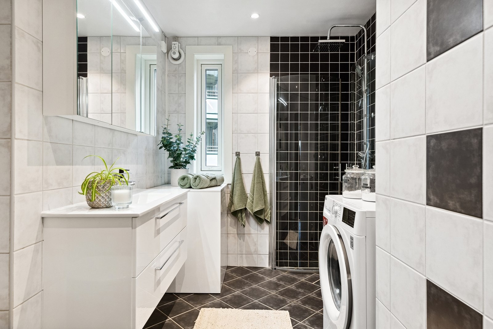 Badet har dusjhjørne, opplegg for vaskemaskin og god oppbevaringsplass i romslig innredning. Galleribilde