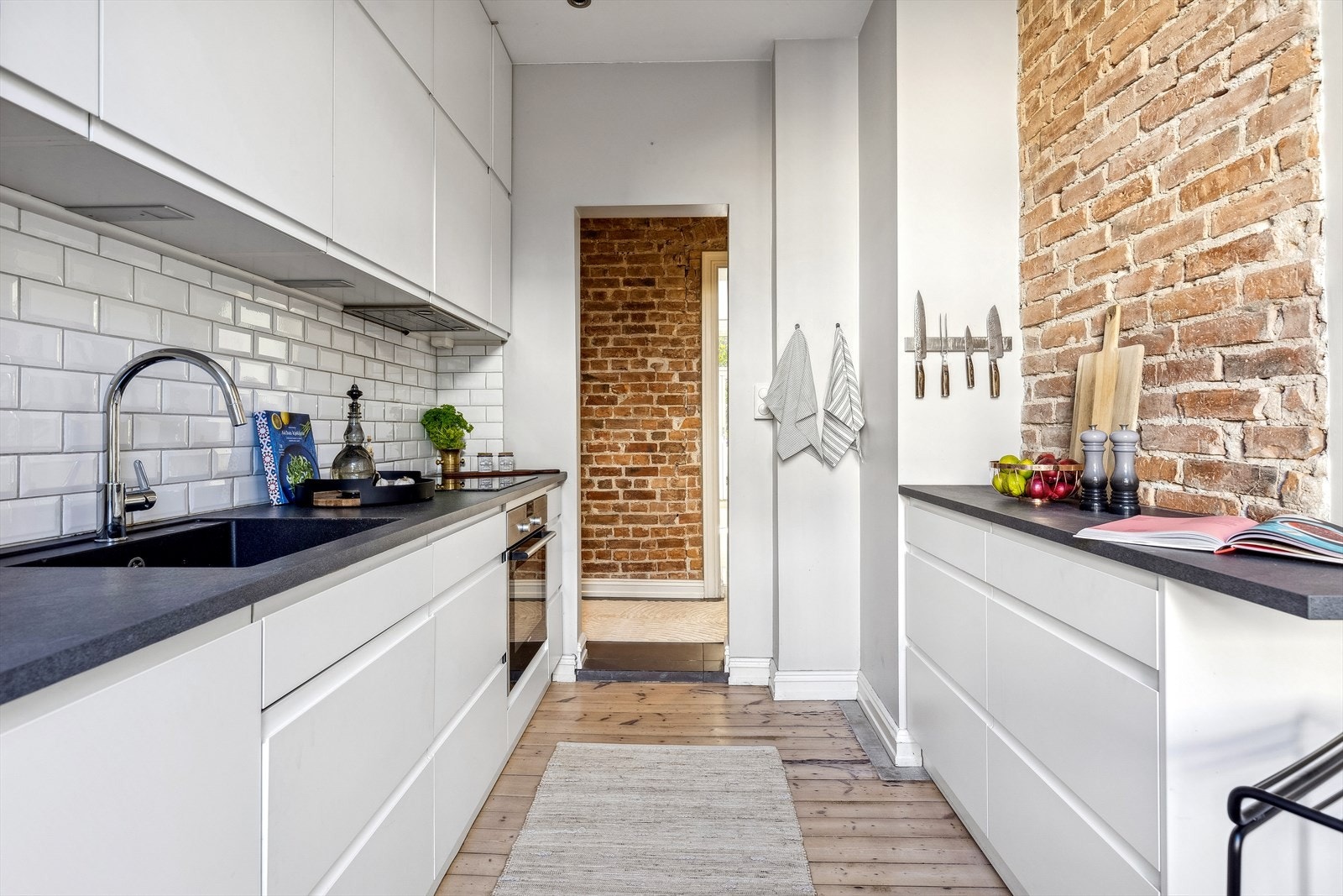 Kjøkkenet er innredet med glatte folierte fronter, laminat benkeplate og fliser på vegg over benk. Galleribilde