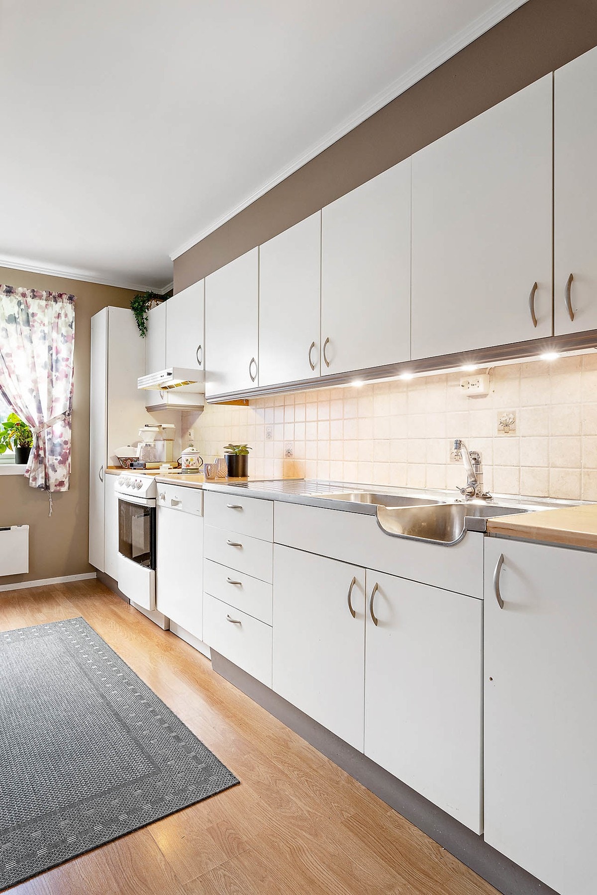 Kjøkkeninnredningen har malte fronter og laminert benkeplate. Hvitevarene er frittstående, men medfølger i handelen. Galleribilde