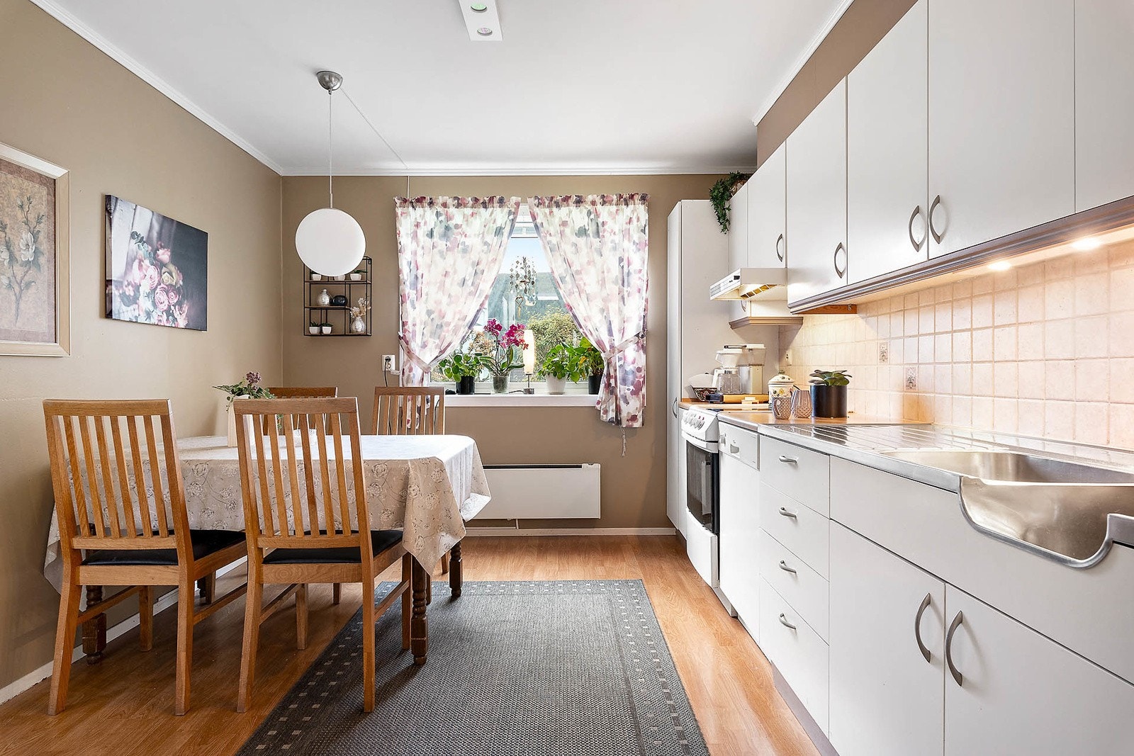 Kjøkken med god plass til spisebord, og godt med arbeidsplass og oppbevaringsplass i både over- og underskap. Galleribilde