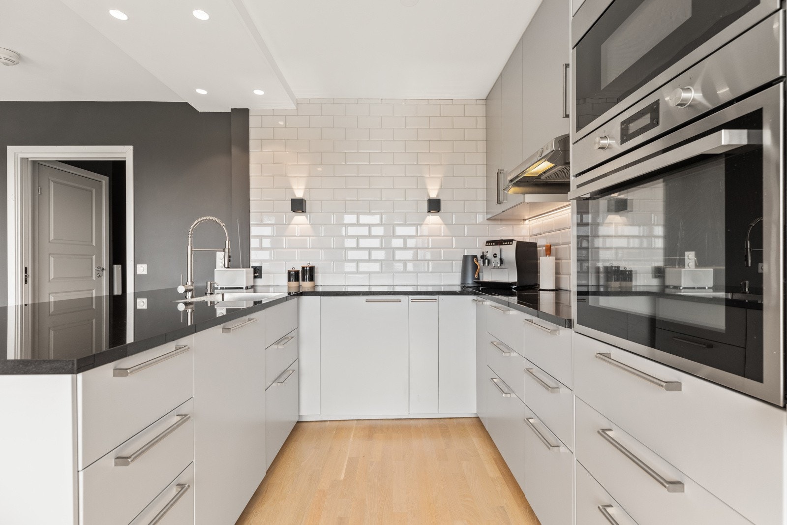 Innholdsrikt og stilrent kjøkken holdt i lyse og moderne farger Galleribilde