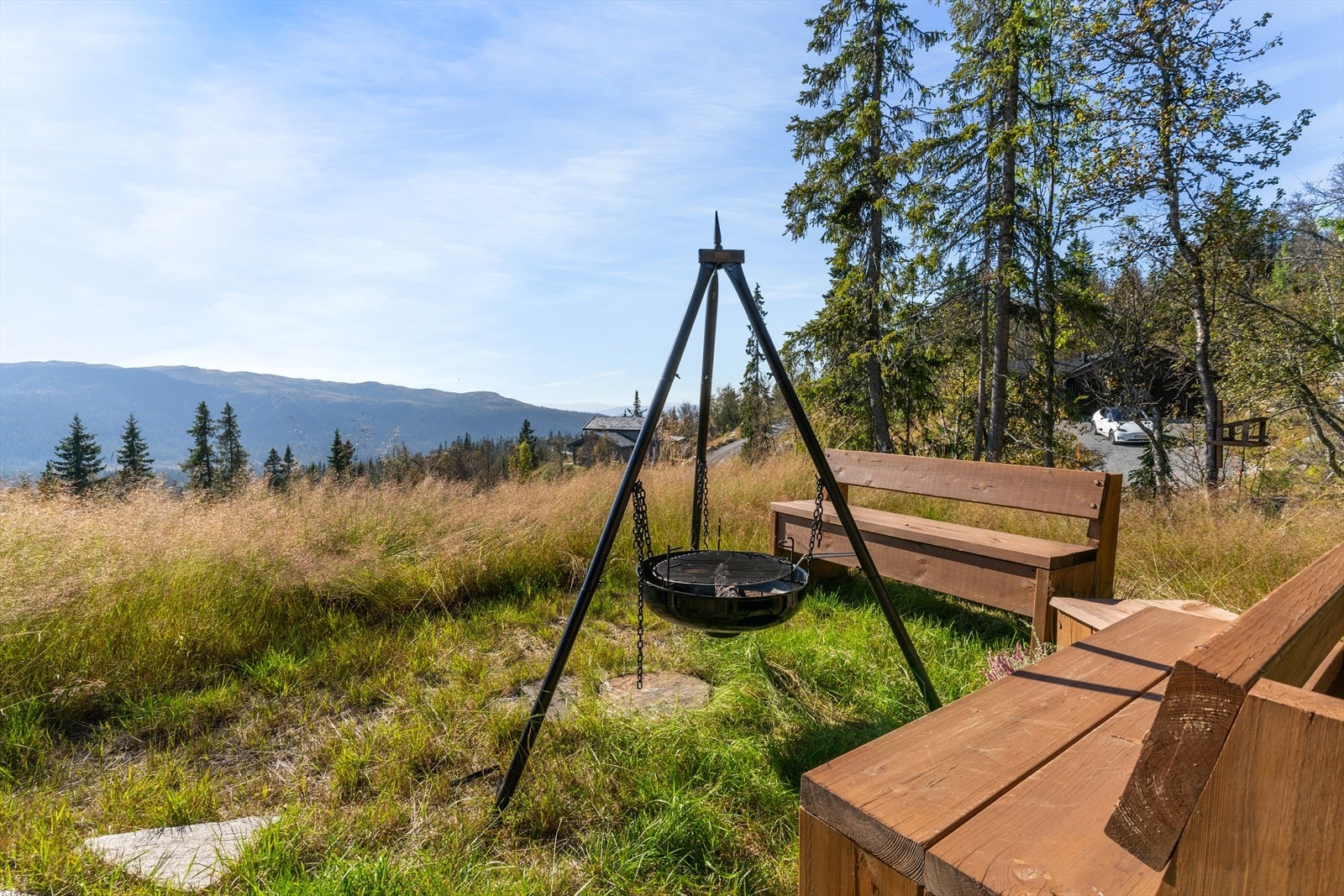 Koselig uteplass med bålpanne og solide benker, som følger med salget Galleribilde