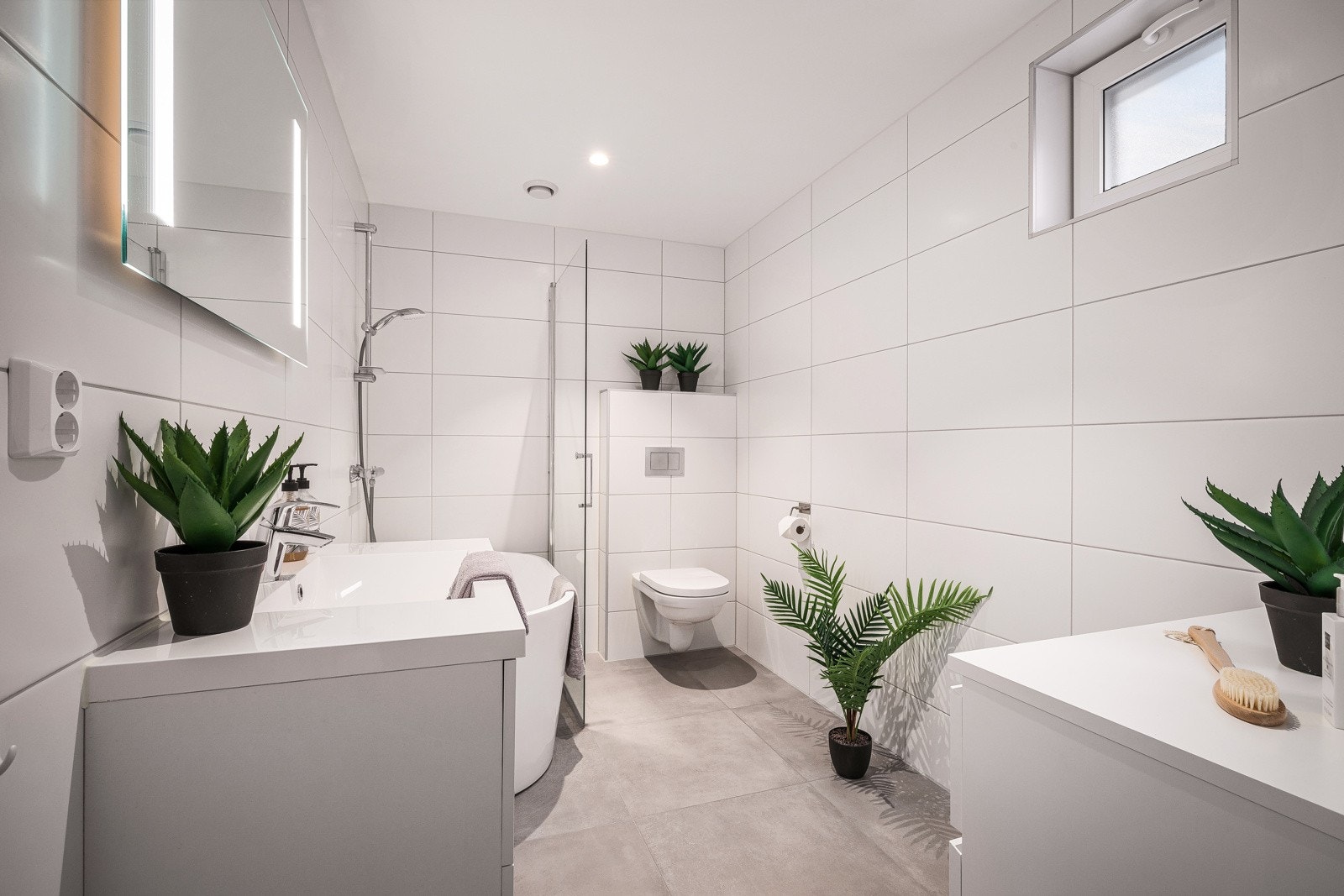 Badet i 1. etasje er innredet med vegghengt toalett, dusj med glassvegg og baderomsinnredning. Galleribilde