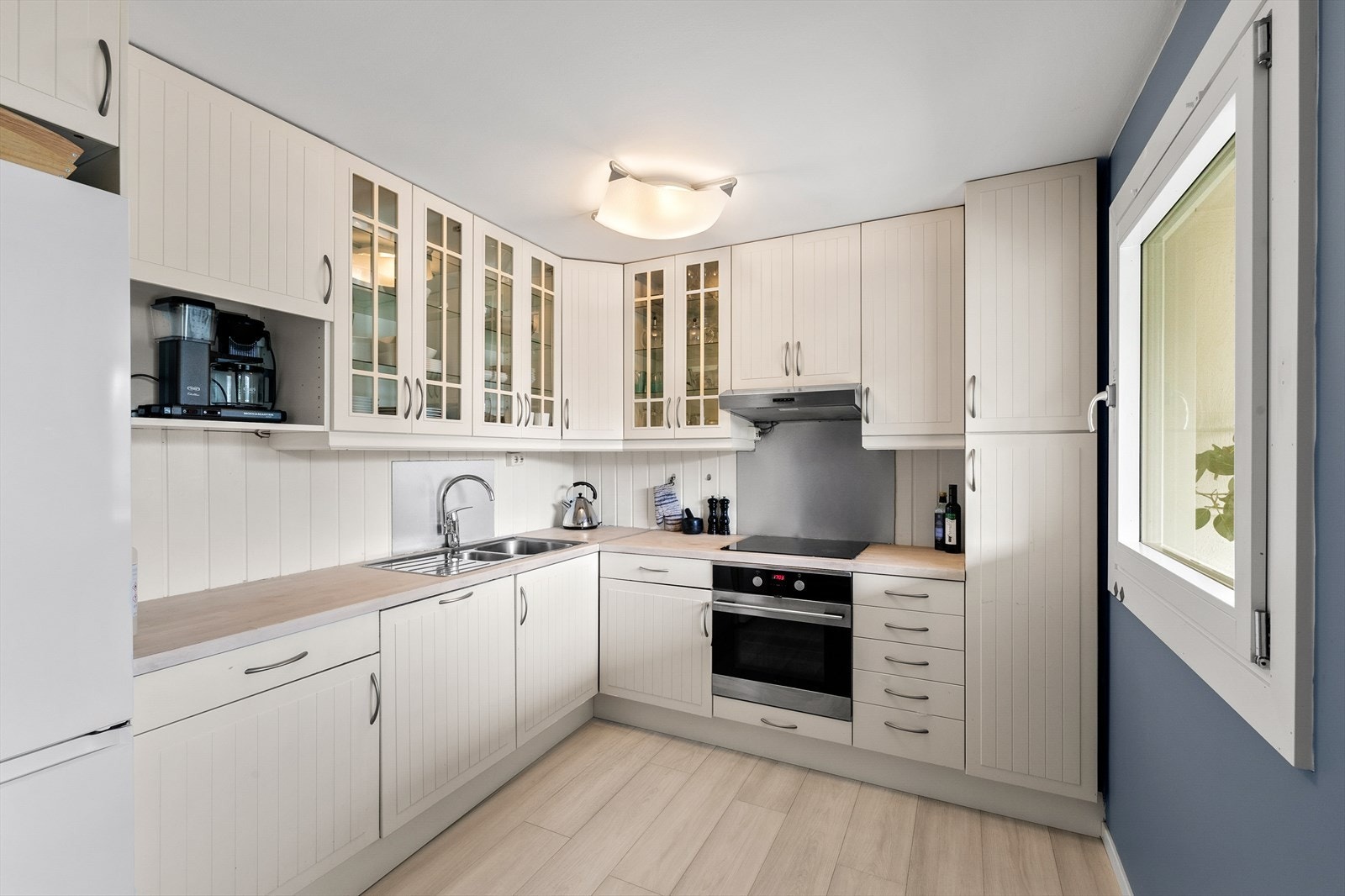Pent og praktisk kjøkken med profilerte fronter og laminat benkeplate. Galleribilde