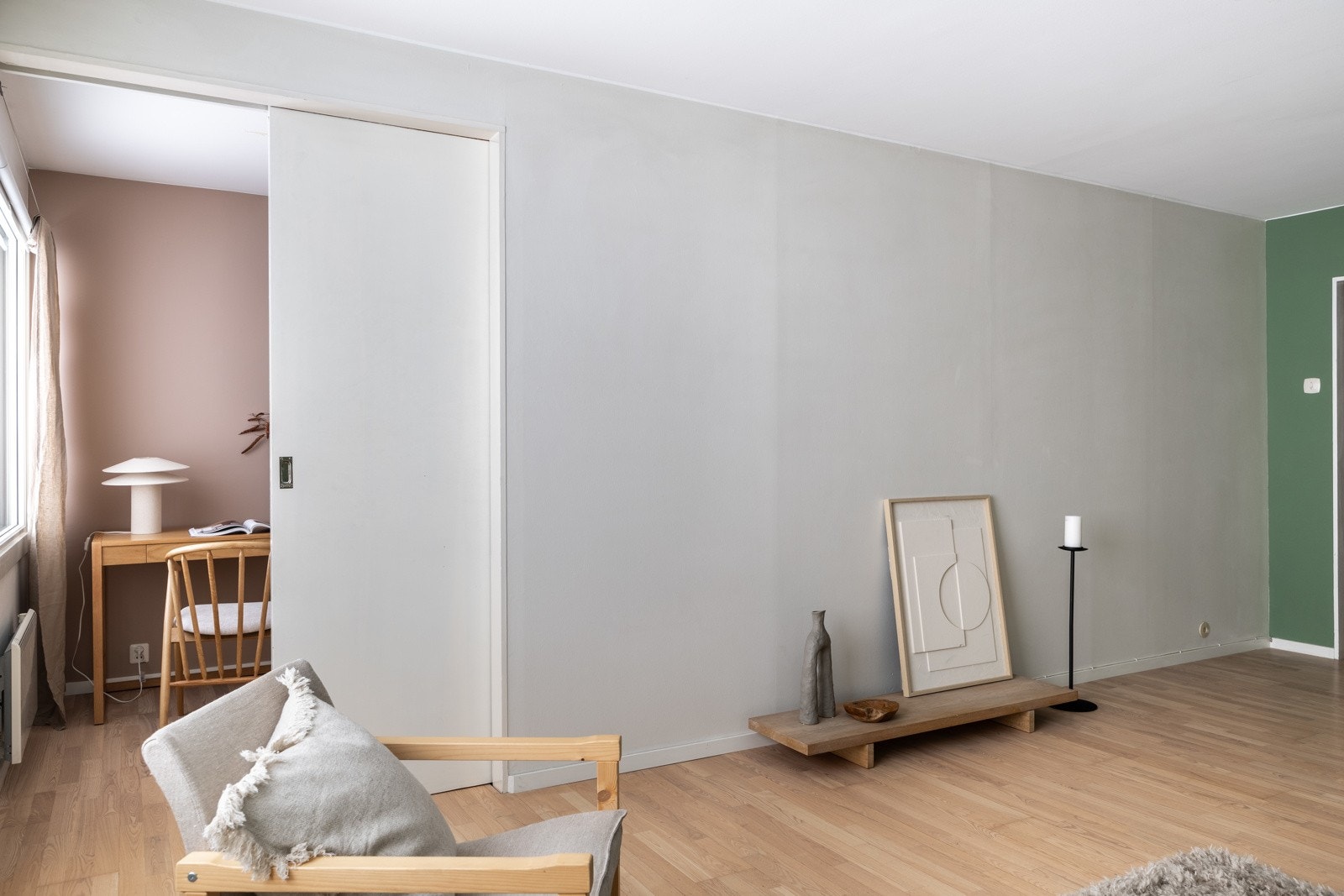 Skyvedøren mellom soverommet og stuen gir ekstra veggplass, noe som gir rommet et mer fleksibelt og funksjonelt utseende. Galleribilde