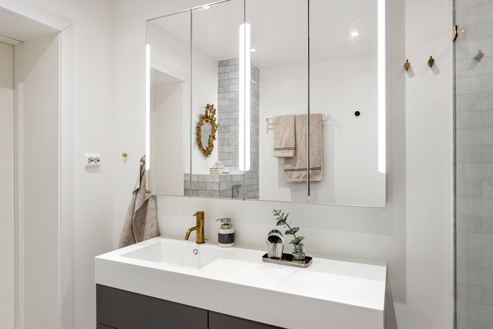 Baderommet har flotte marmorfliser fra Ulvfen kombinert med glatte lysmalte overflater, deilig gulvvarme og downlights i himlingen. Galleribilde