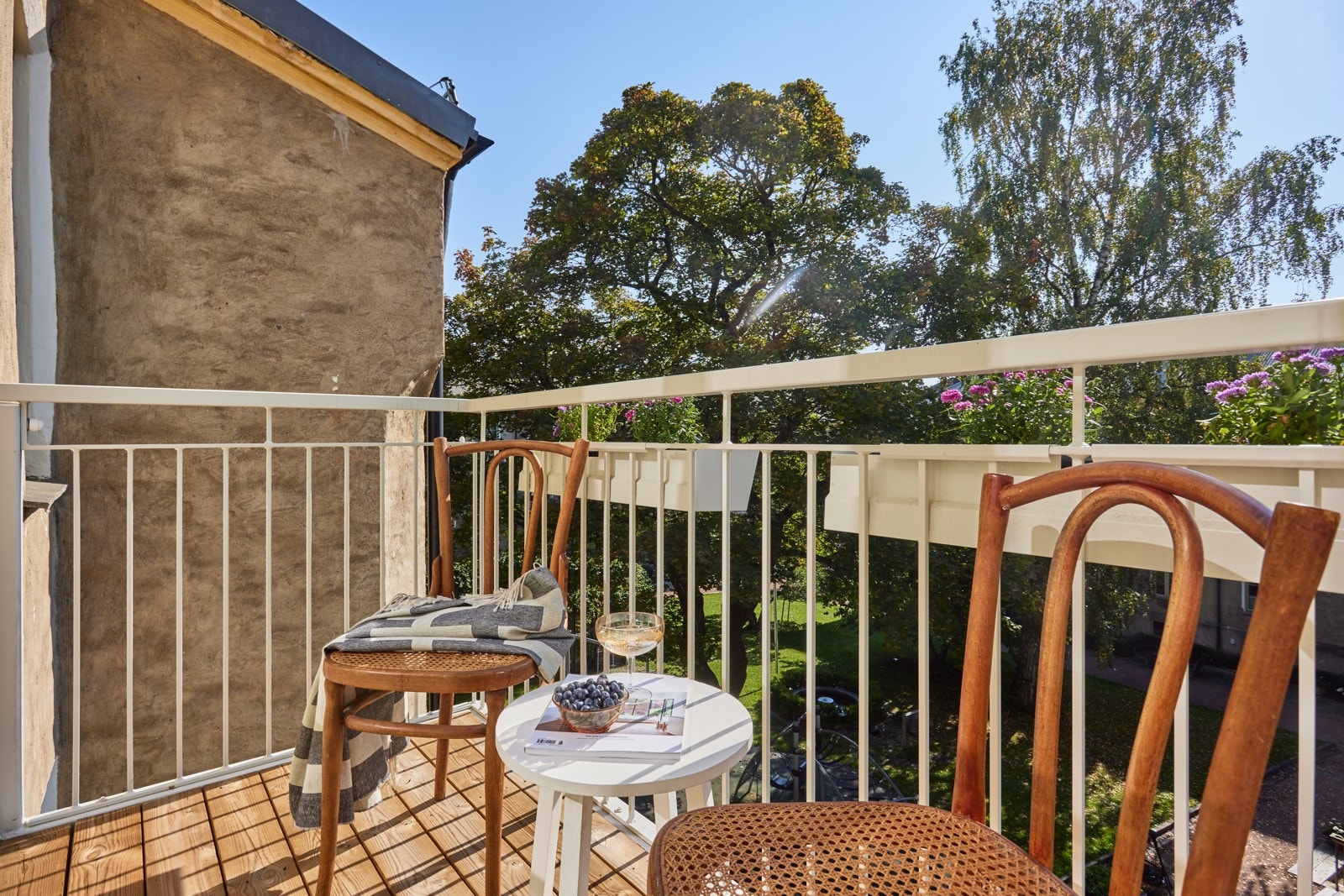 Balkongen har terrassebord på gulv, rekkverk av metall og plass til sittegruppe. Galleribilde