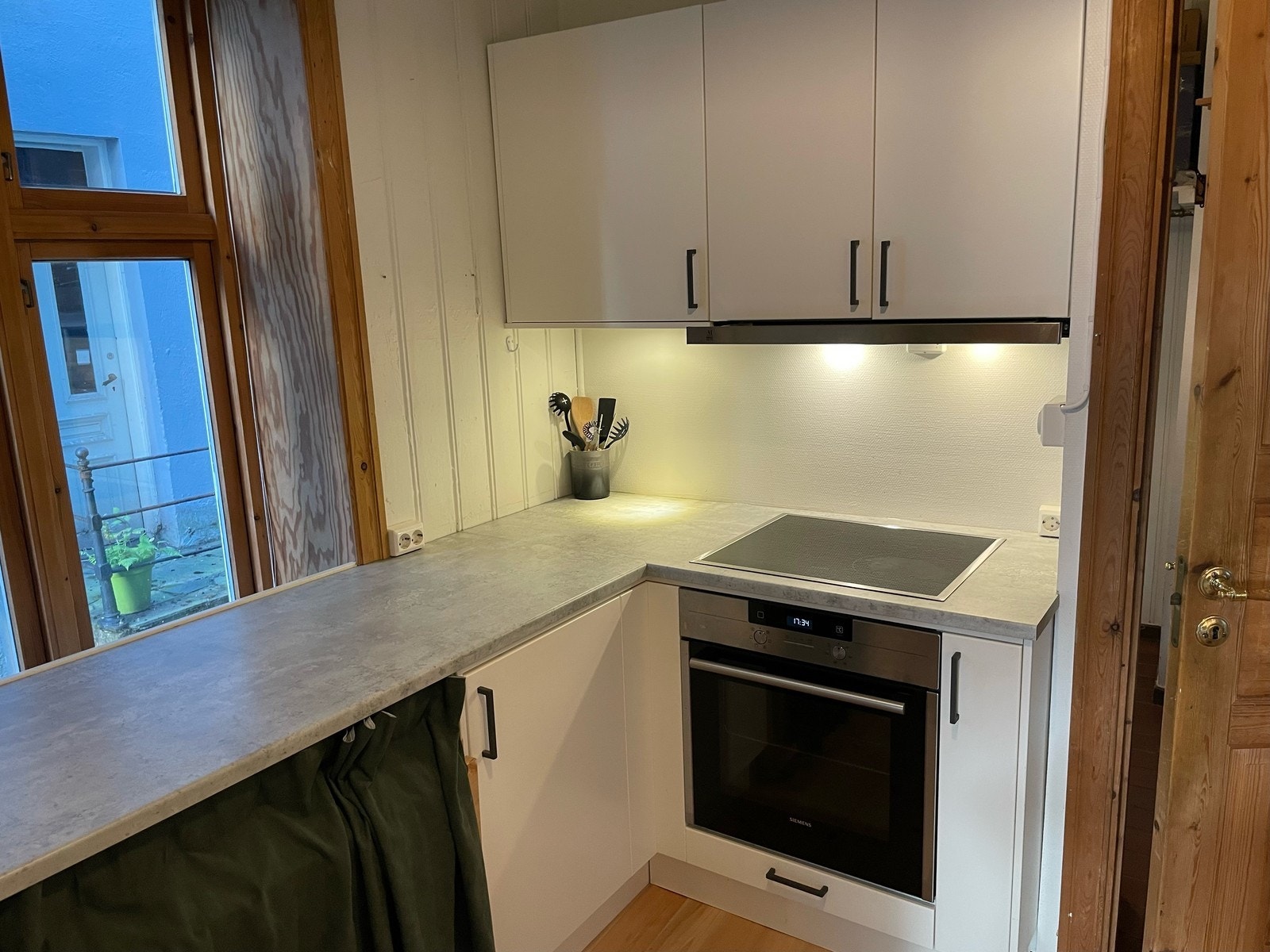 Stilrent kjøkken utstyrt med integrert stekeovn, platetopp, oppvaskamskin og kombiskap. Galleribilde