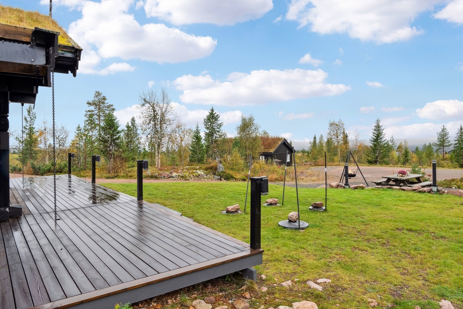 Hytta har et flatt og fint plenområde i sammenheng med terrassen Galleribilde