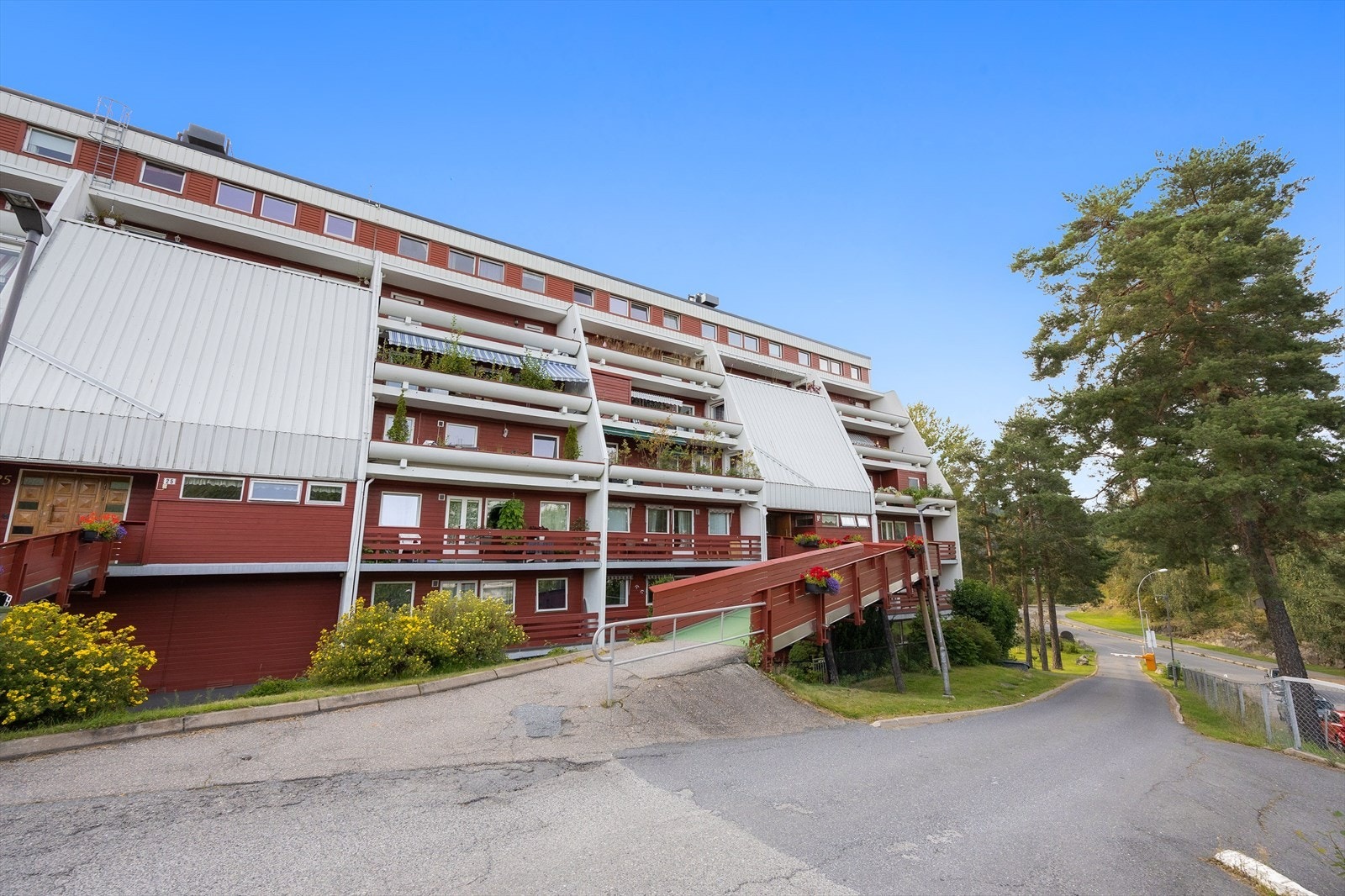 Bygningens fasade med flere balkonger og grøntområder Galleribilde
