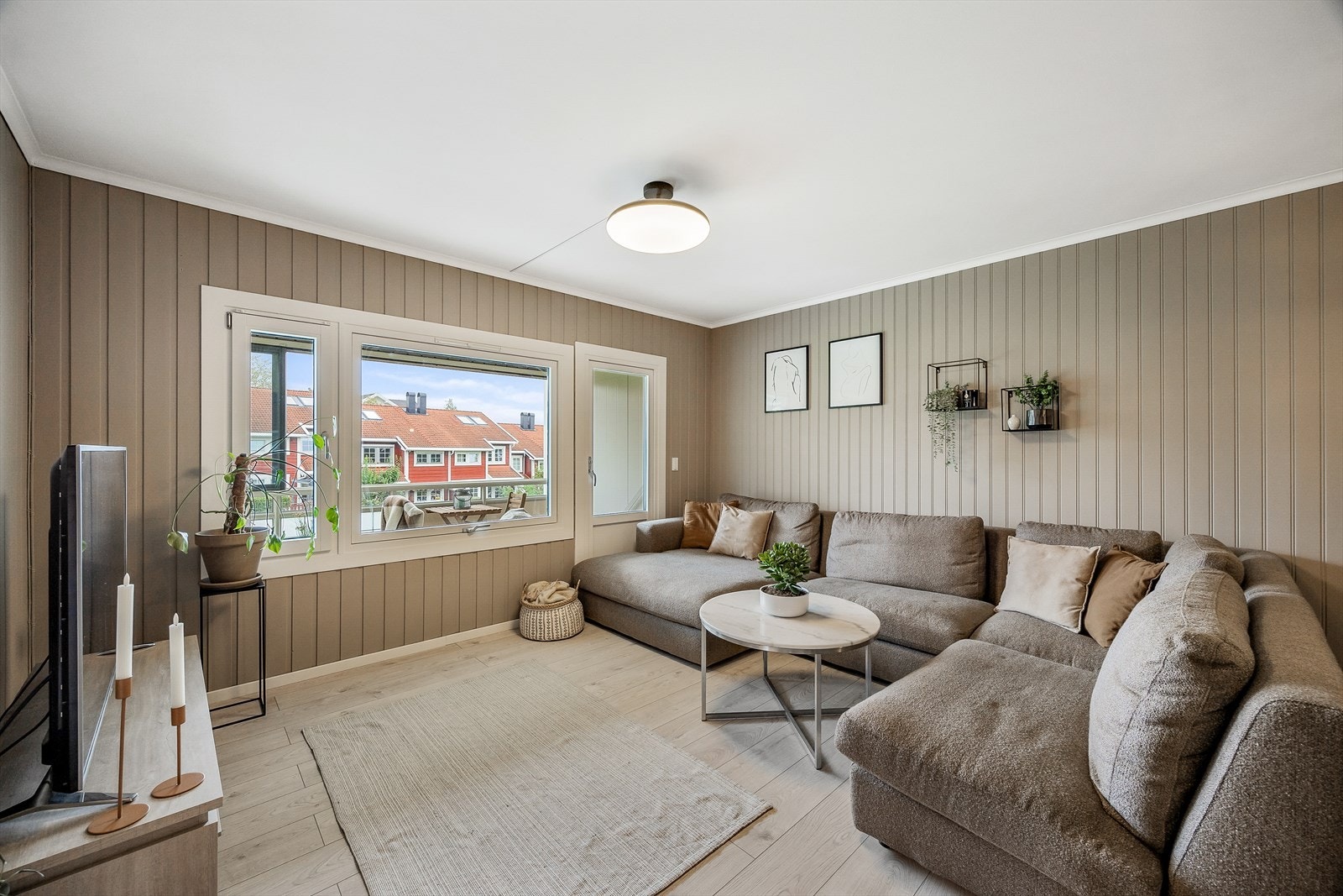 Lys stue med store vinduer og plass til sofa. Galleribilde