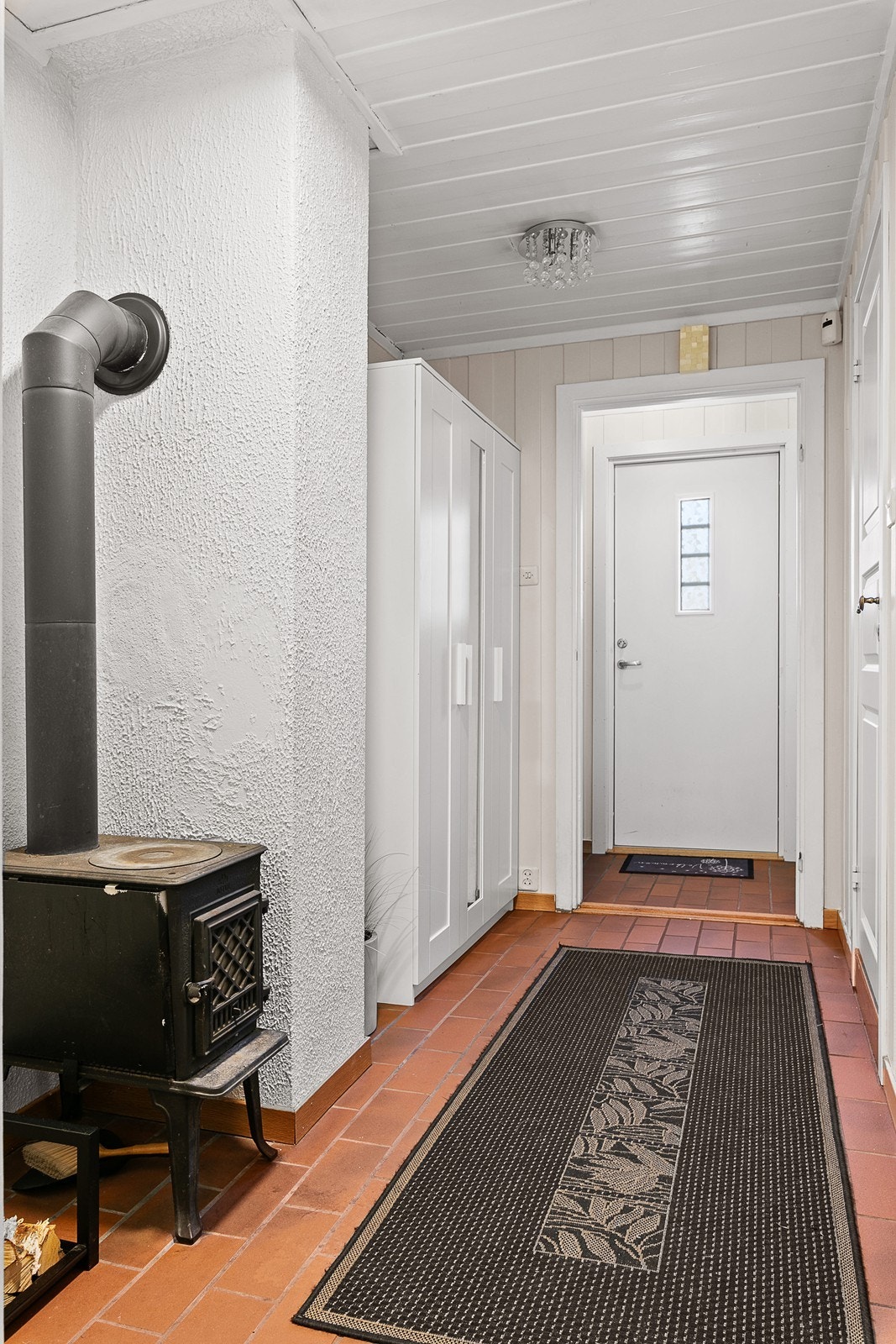 Gang i 1. etasje med garderobeskap og vedovn Galleribilde