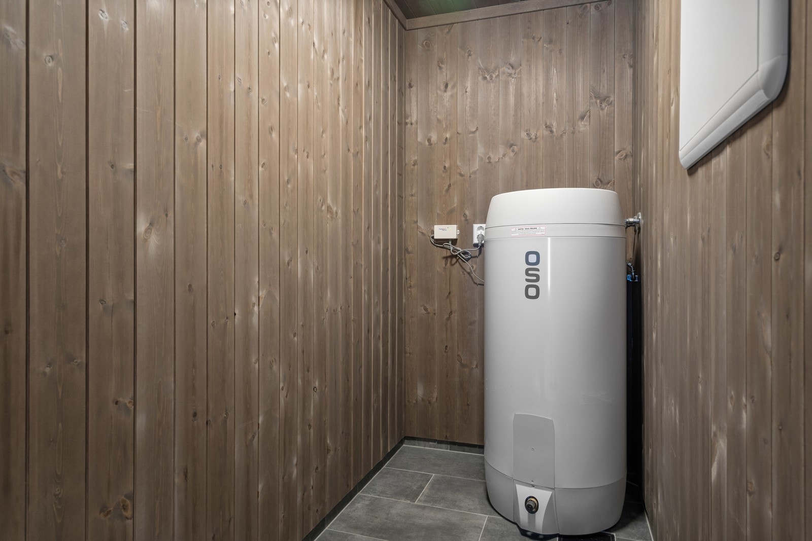 Flislagt gulv med varmekabler finner en også i hyttas tekniske rom hvor varmtvannsberederen er plassert. Her er det også god oppbevaringsplass. (Illustrasjonsfoto fra lik nabohytte) Galleribilde